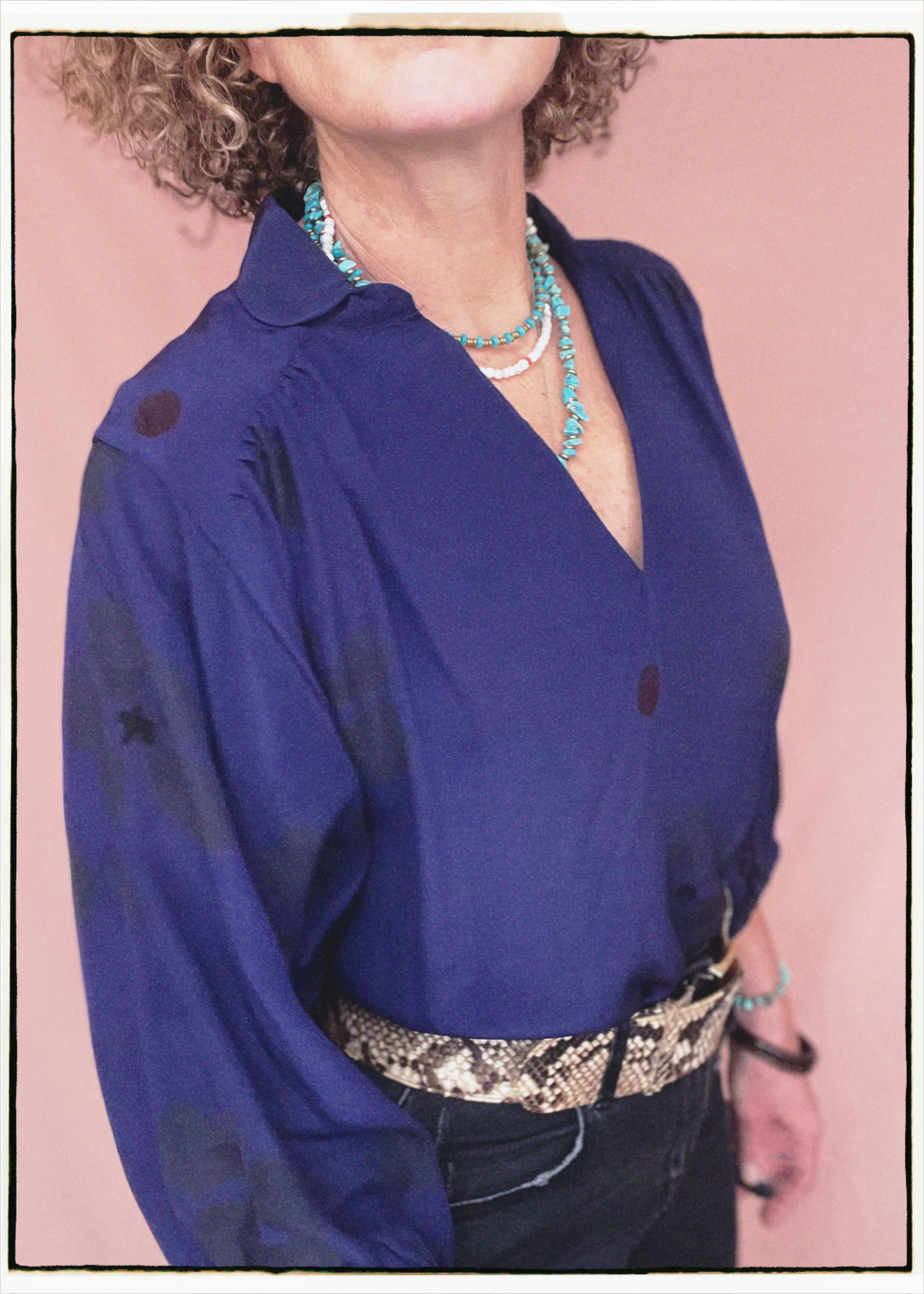 Woman wearing a bohemian style balloon sleeved blouse made from vintage repurposed Indian silk crepe sari in front of a plain background