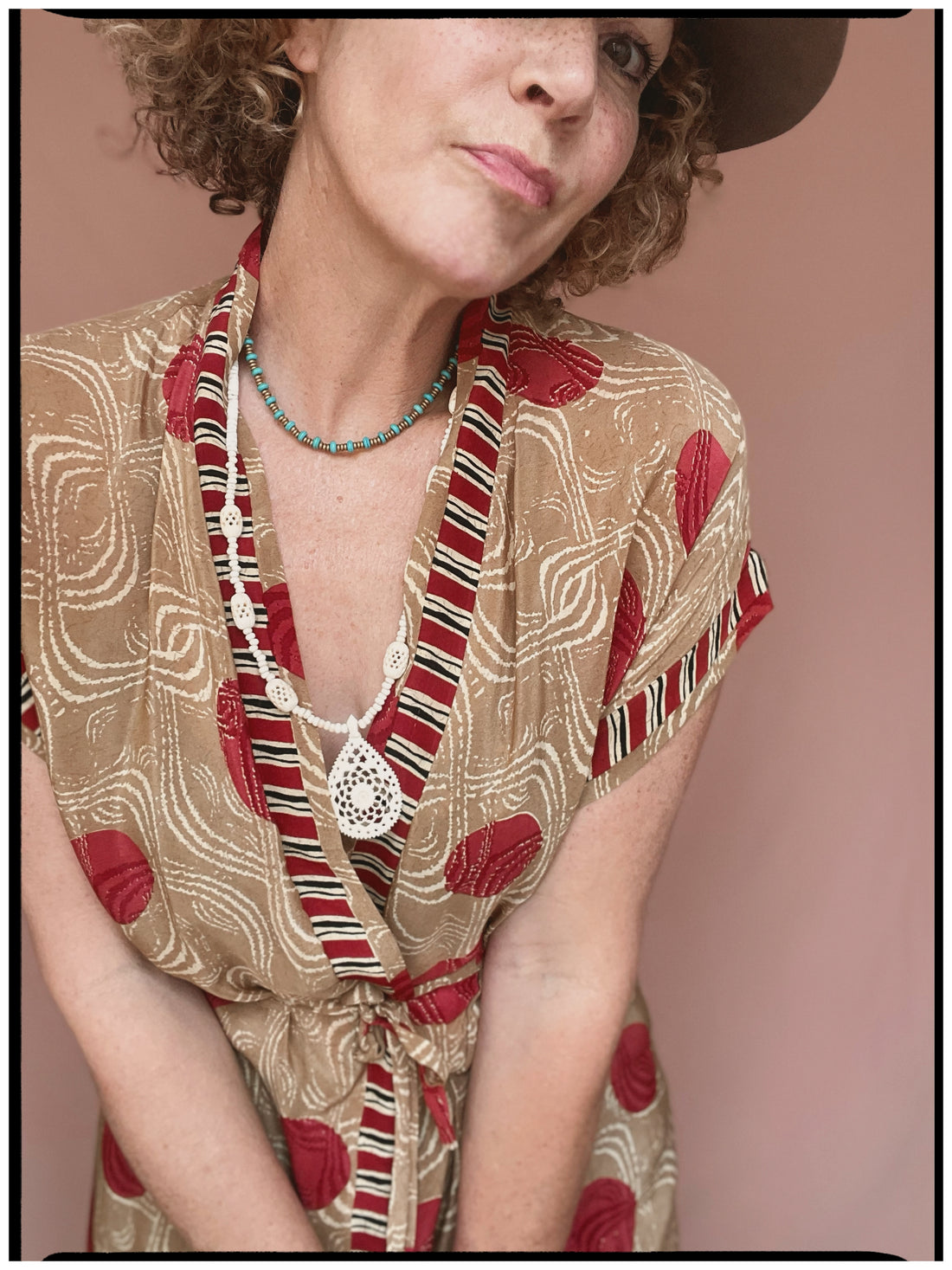 Woman wearing a bohemian style balloon sleeved patterned blouse made from vintage repurposed Indian silk crepe sari in front of a plain background