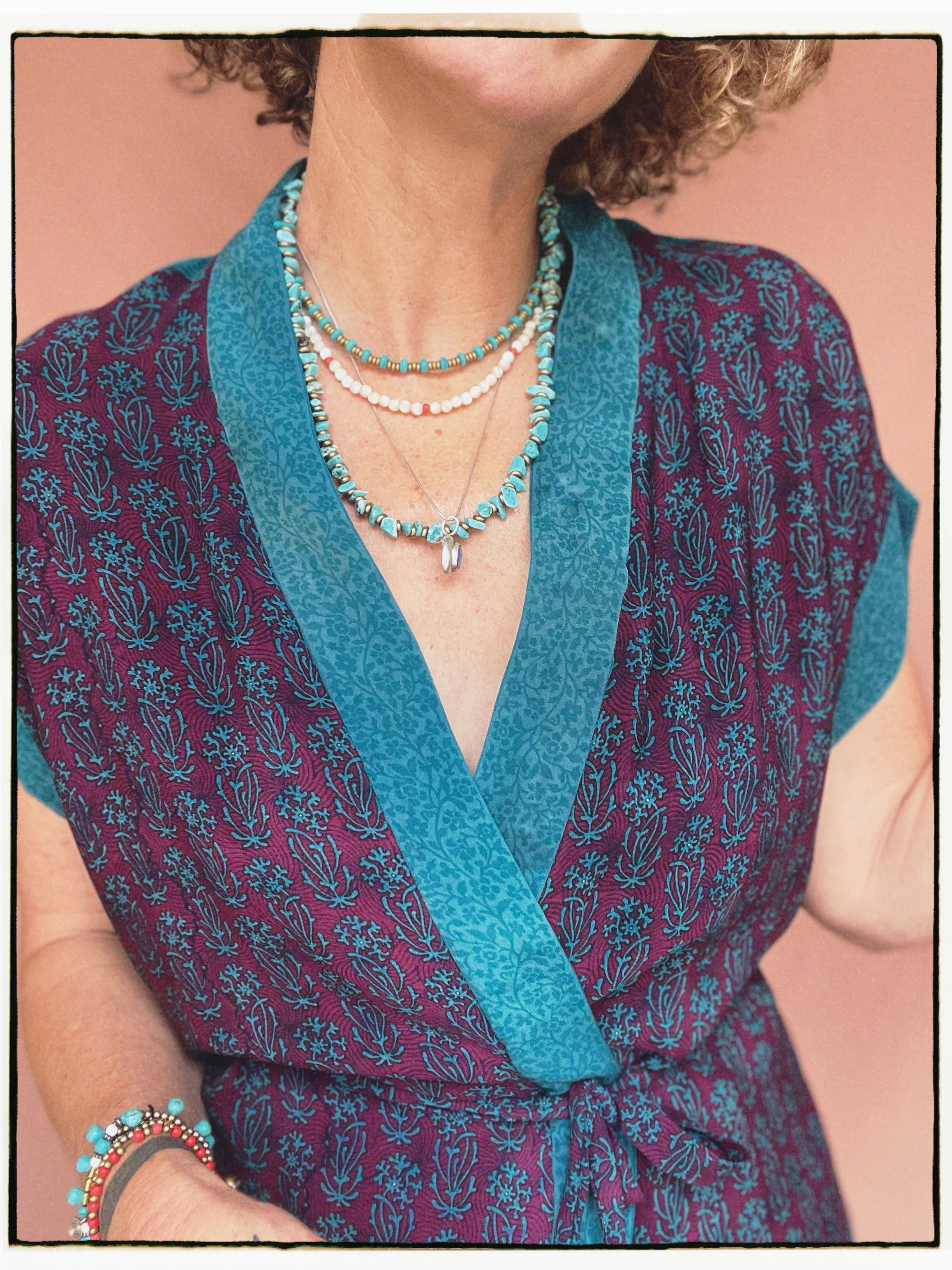Woman wearing a bohemian style balloon sleeved patterned blouse made from vintage repurposed Indian silk crepe sari in front of a plain background