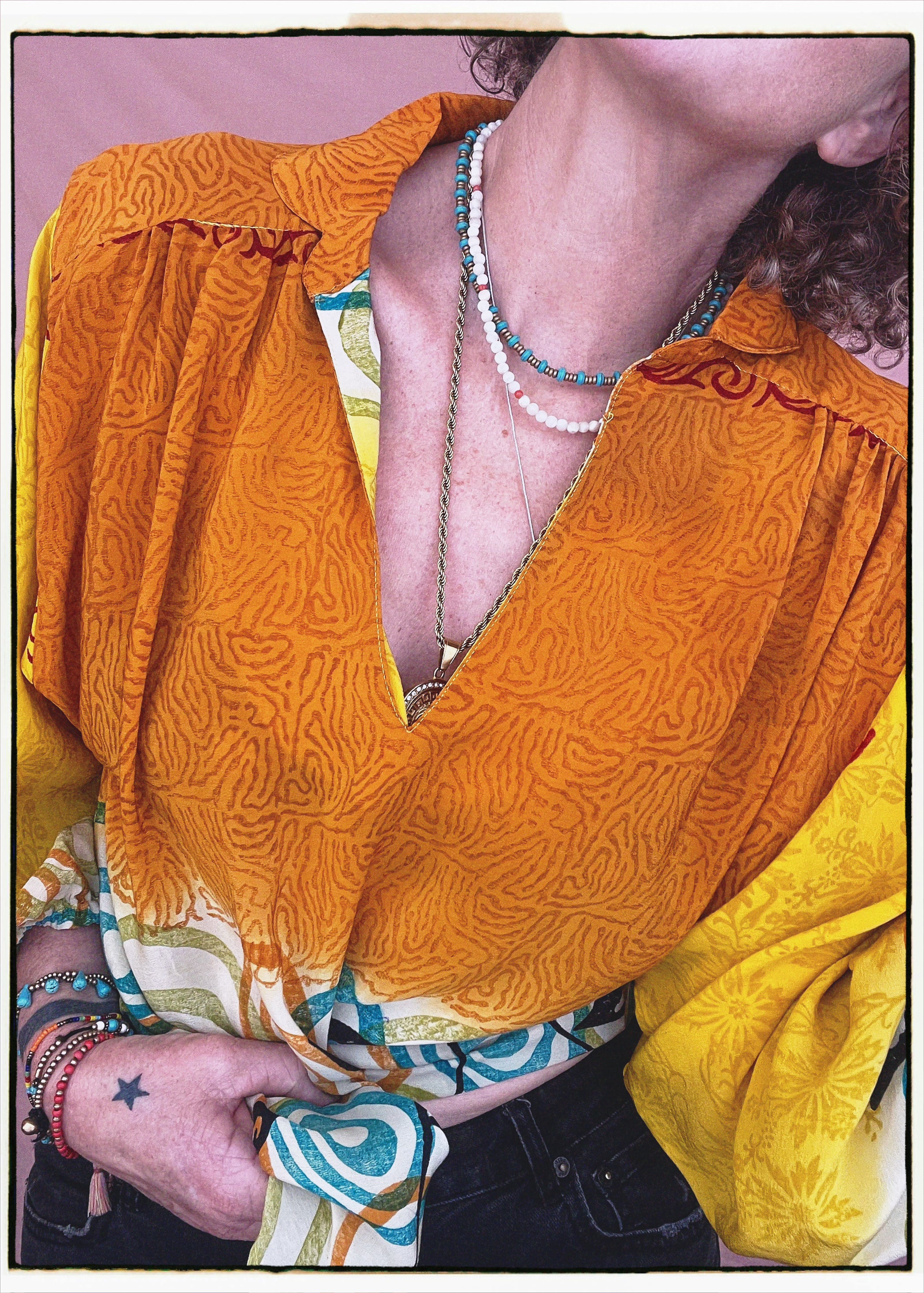 Woman wearing a bohemian style balloon sleeved blouse made from vintage repurposed Indian silk crepe sari in front of a plain background