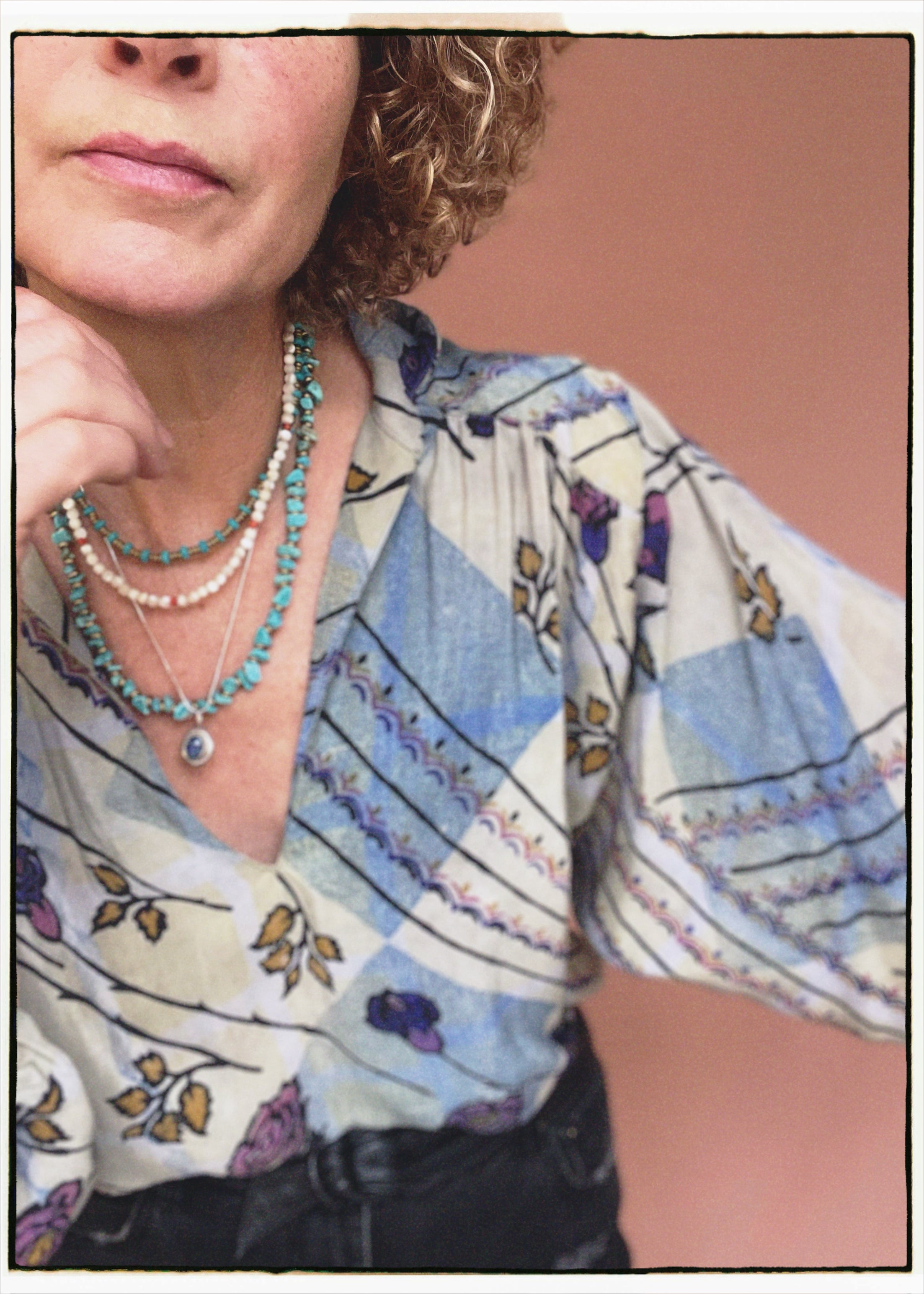 Woman wearing a bohemian style balloon sleeved patterned blouse made from vintage repurposed Indian silk crepe sari in front of a plain background