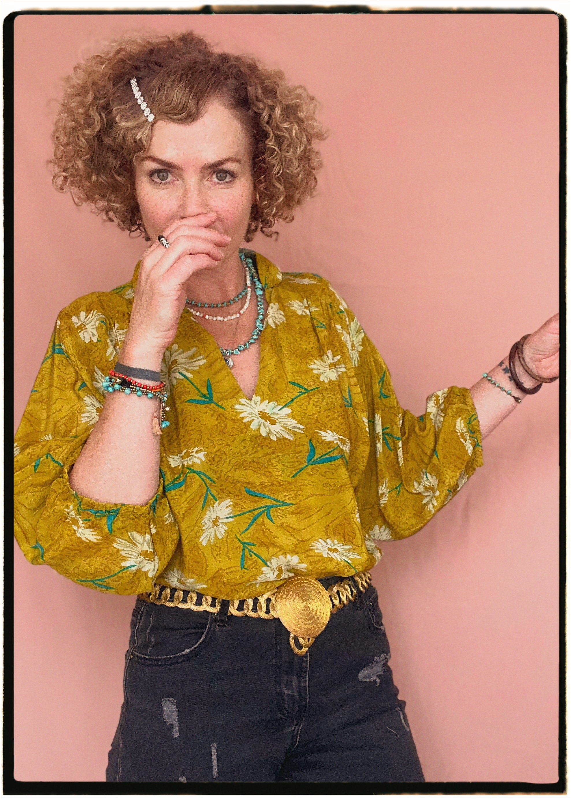 Woman wearing a bohemian style balloon sleeved blouse made from vintage repurposed Indian silk crepe sari in front of a plain background