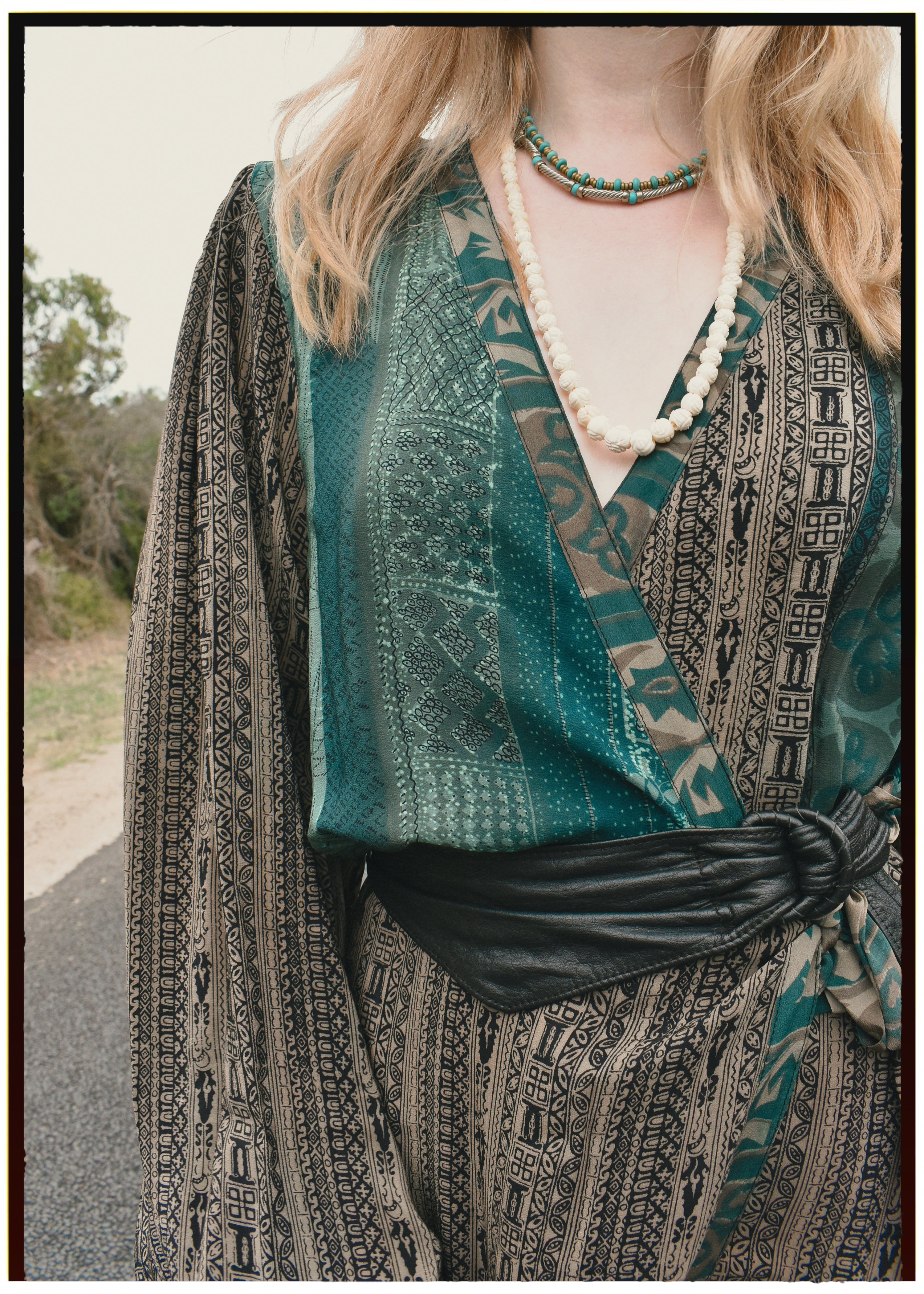 Woman wearing a bohemian style balloon sleeved blouse made from vintage repurposed Indian silk crepe sari in front of a plain background
