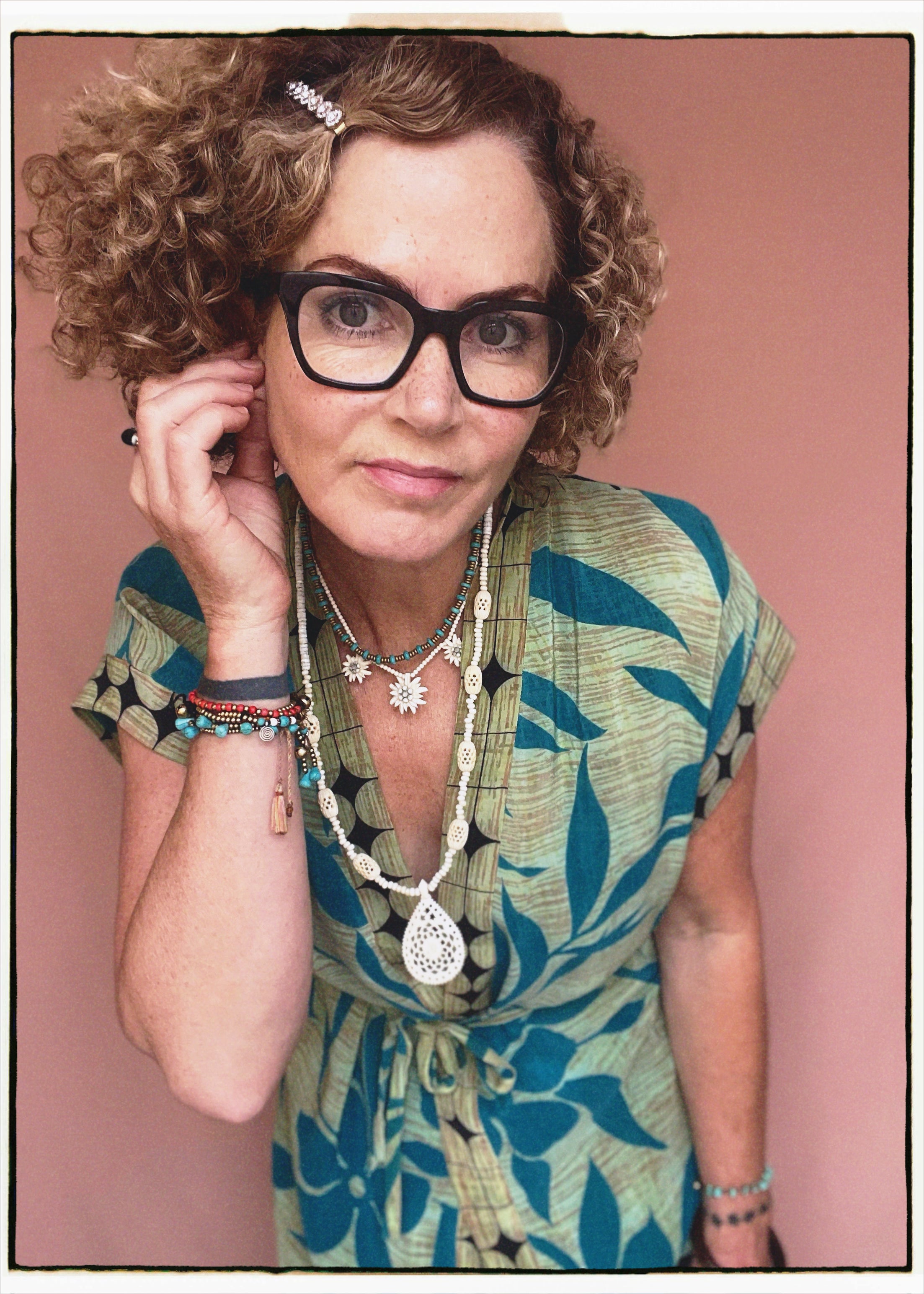 Woman wearing a bohemian style balloon sleeved patterned blouse made from vintage repurposed Indian silk crepe sari in front of a plain background
