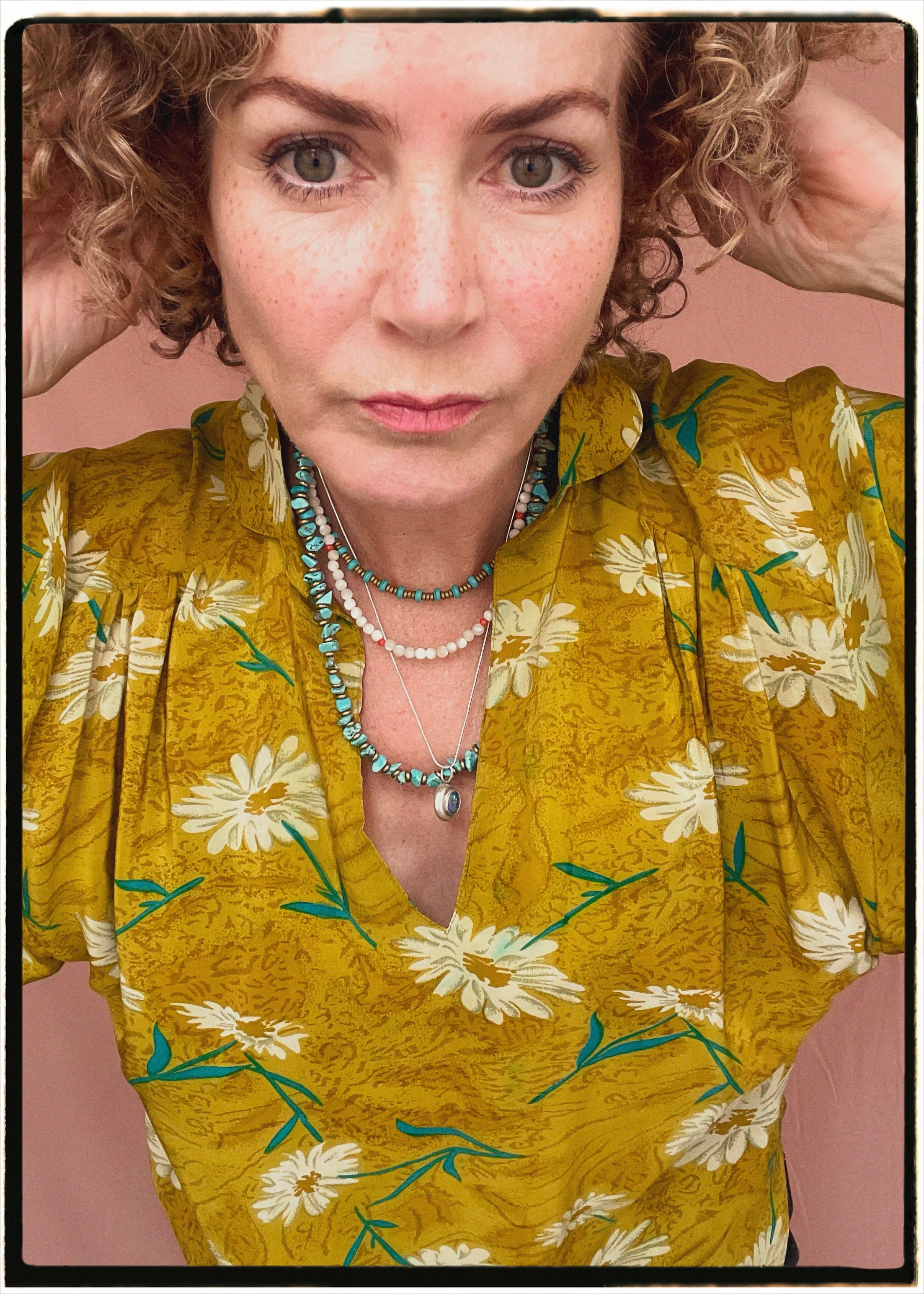 Woman wearing a bohemian style balloon sleeved blouse made from vintage repurposed Indian silk crepe sari in front of a plain background