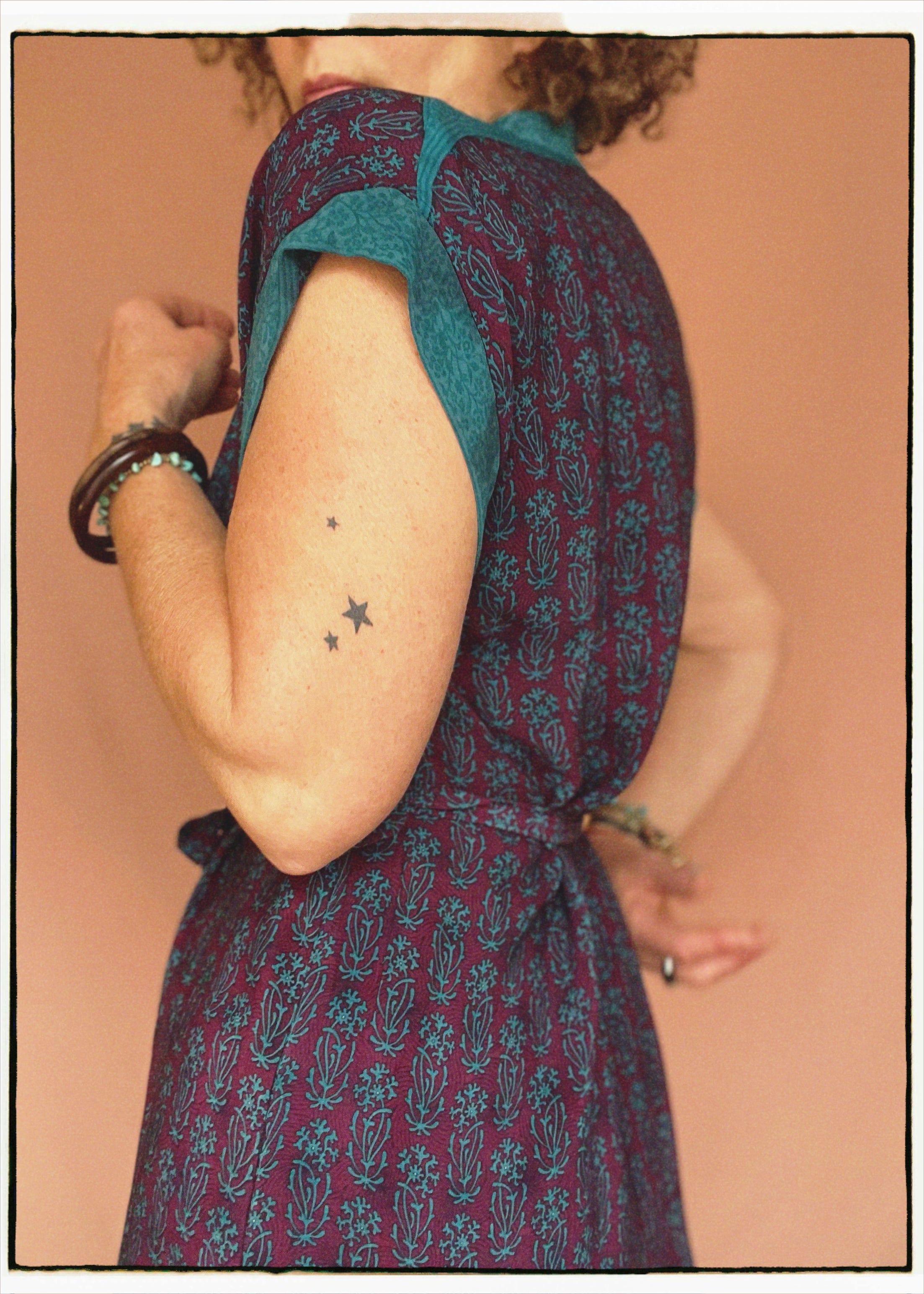 Woman wearing a bohemian style balloon sleeved patterned blouse made from vintage repurposed Indian silk crepe sari in front of a plain background