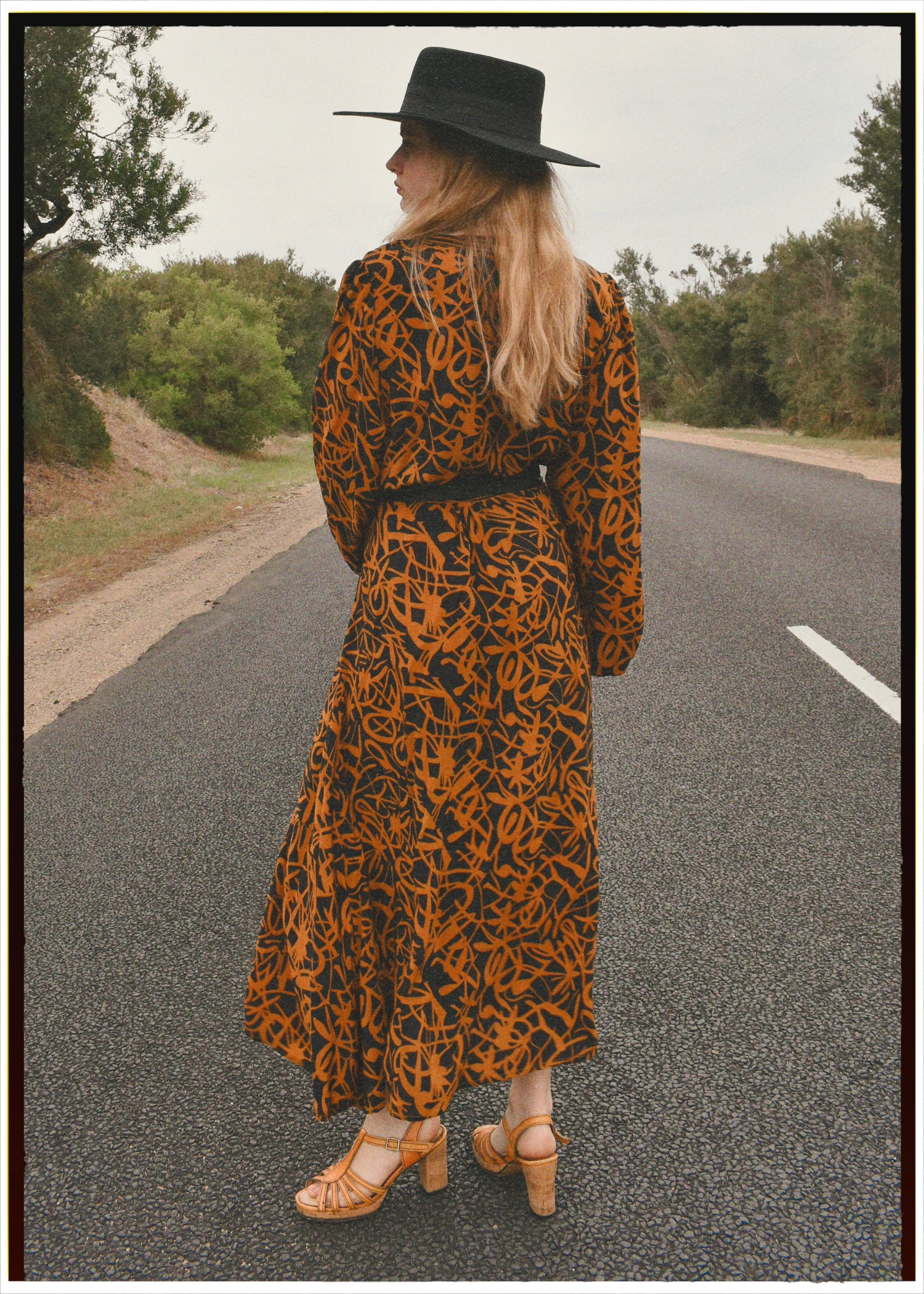 Woman wearing a bohemian style balloon sleeved wrap dress made from vintage repurposed Indian silk crepe sari in front of a plain 
