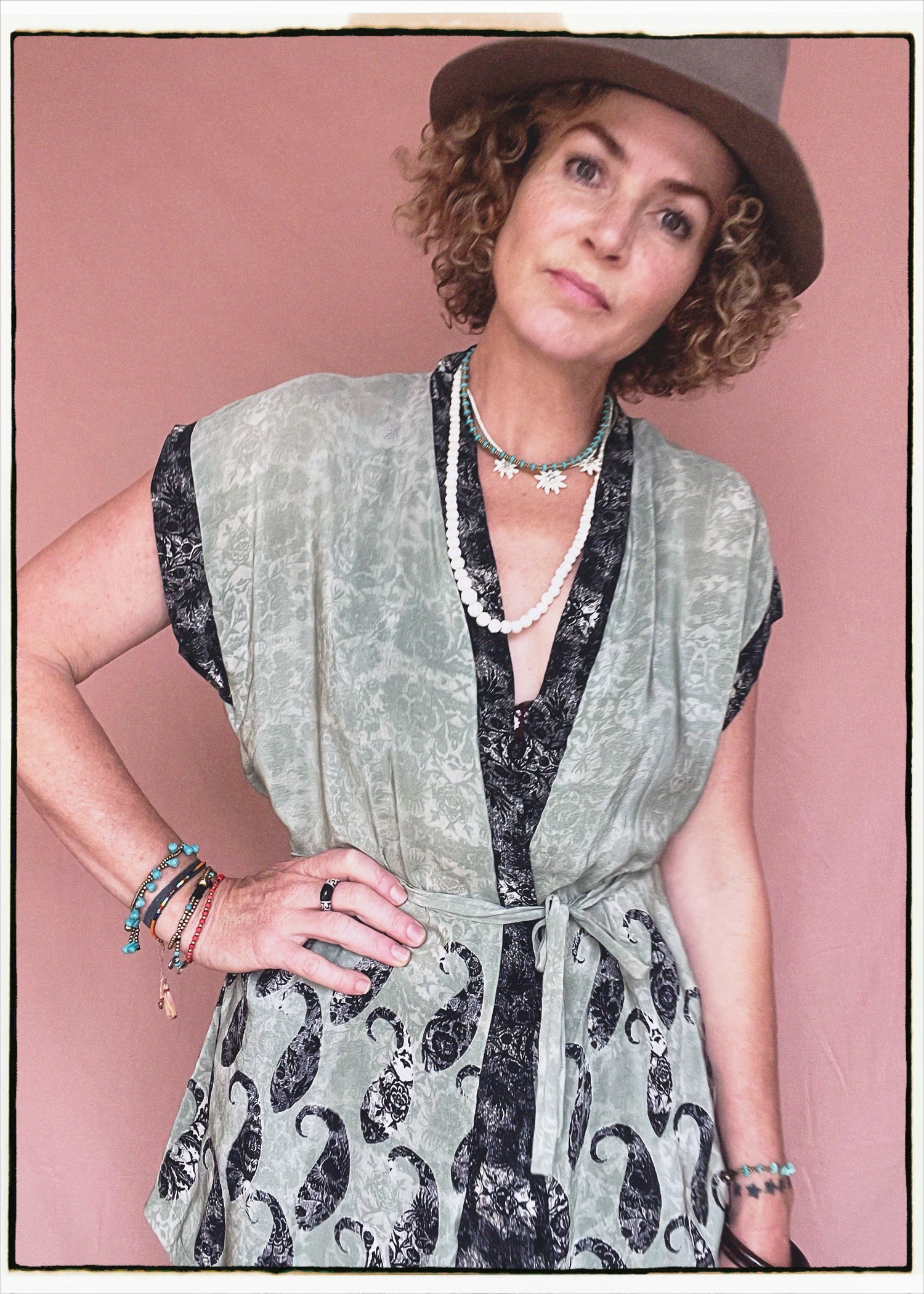 Woman wearing a bohemian style balloon sleeved patterned blouse made from vintage repurposed Indian silk crepe sari in front of a plain background