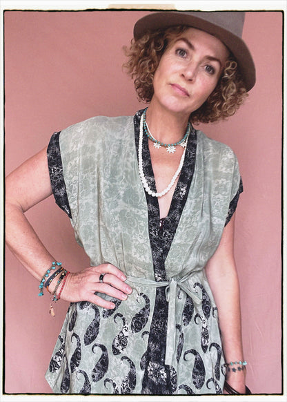 Woman wearing a bohemian style balloon sleeved patterned blouse made from vintage repurposed Indian silk crepe sari in front of a plain background
