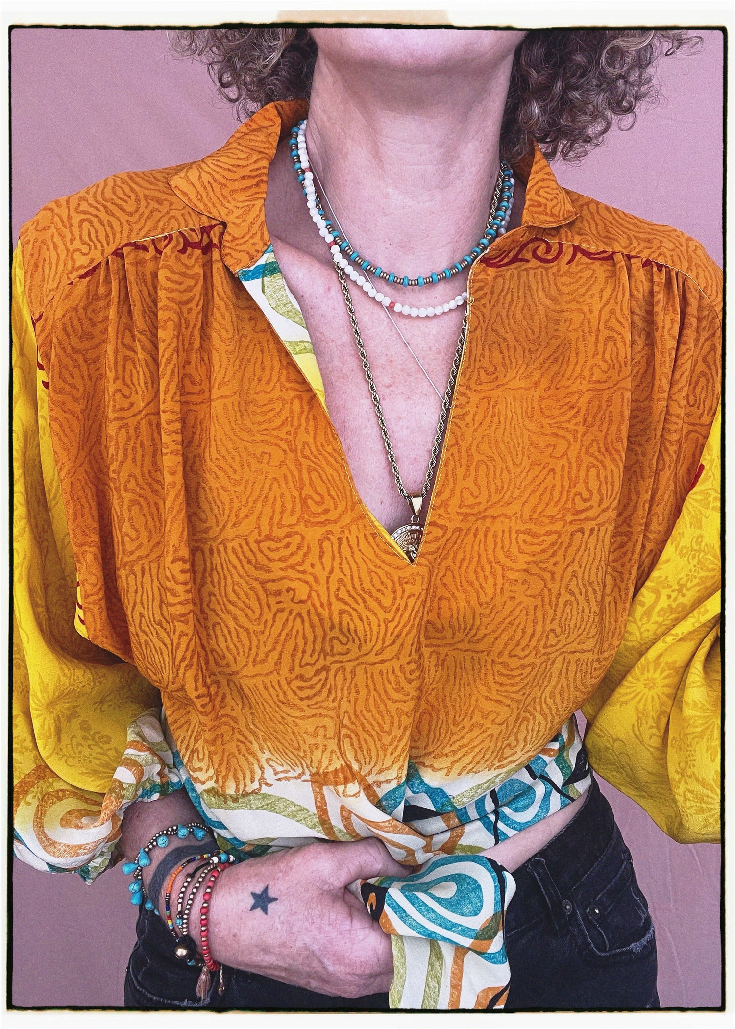Woman wearing a bohemian style balloon sleeved blouse made from vintage repurposed Indian silk crepe sari in front of a plain background
