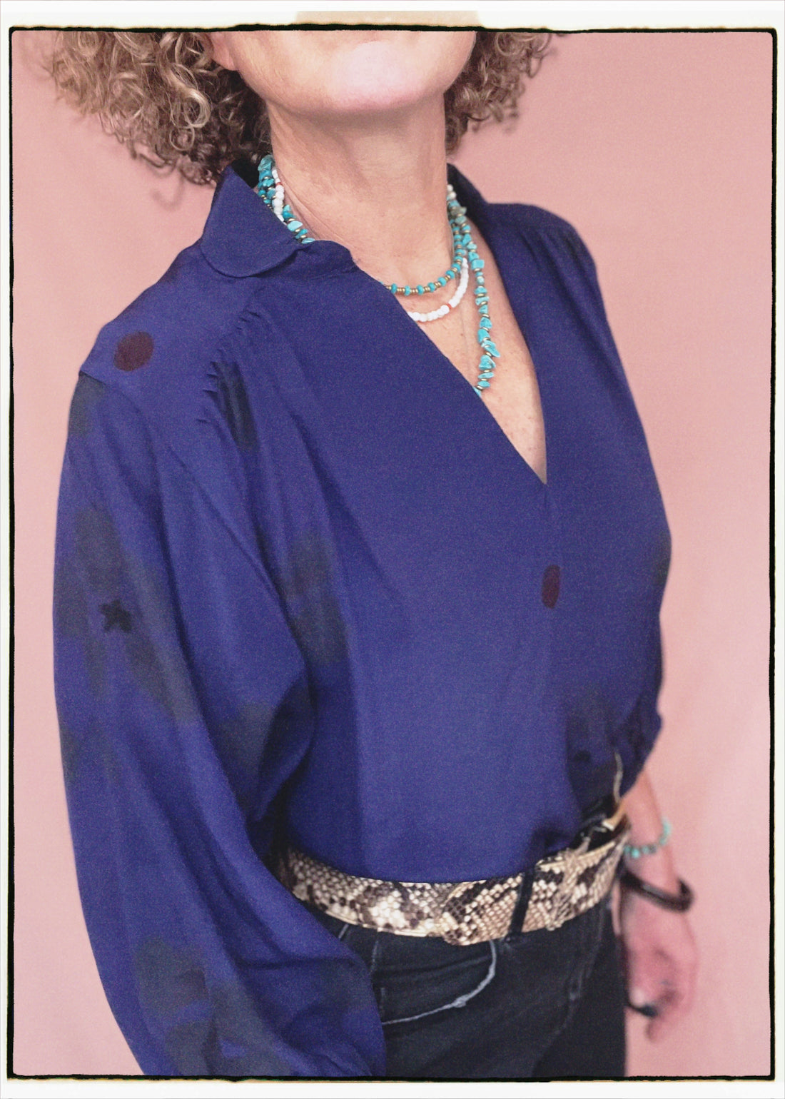Woman wearing a bohemian style balloon sleeved blouse made from vintage repurposed Indian silk crepe sari in front of a plain background