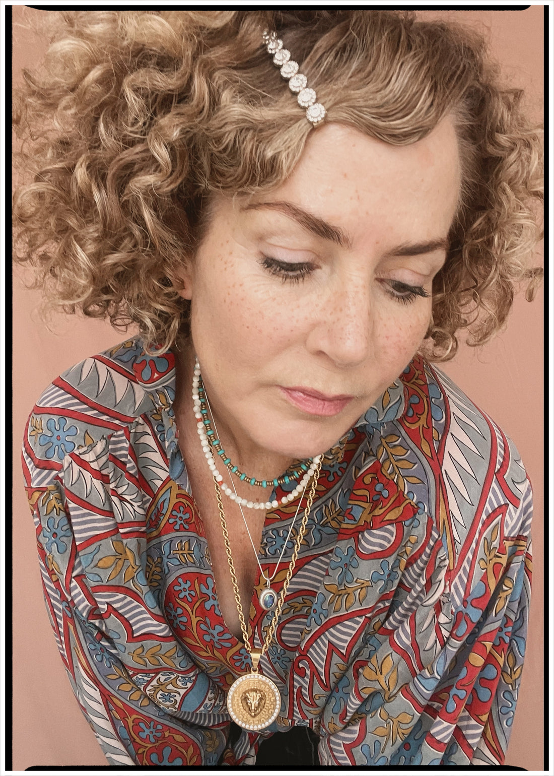 Woman wearing a bohemian style balloon sleeved patterned blouse made from vintage repurposed Indian silk crepe sari in front of a plain background