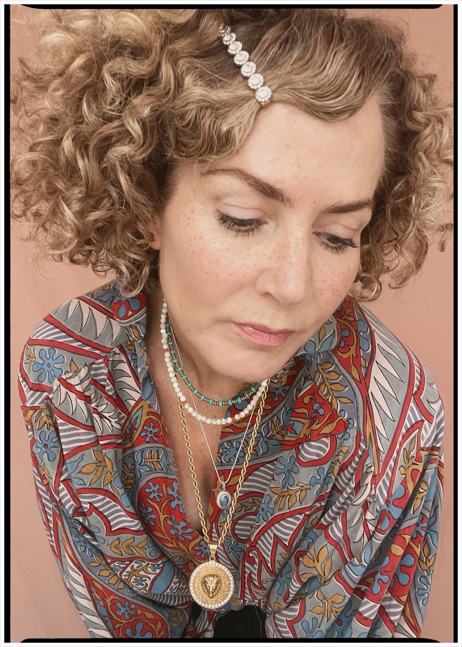 Woman wearing a bohemian style balloon sleeved patterned blouse made from vintage repurposed Indian silk crepe sari in front of a plain background