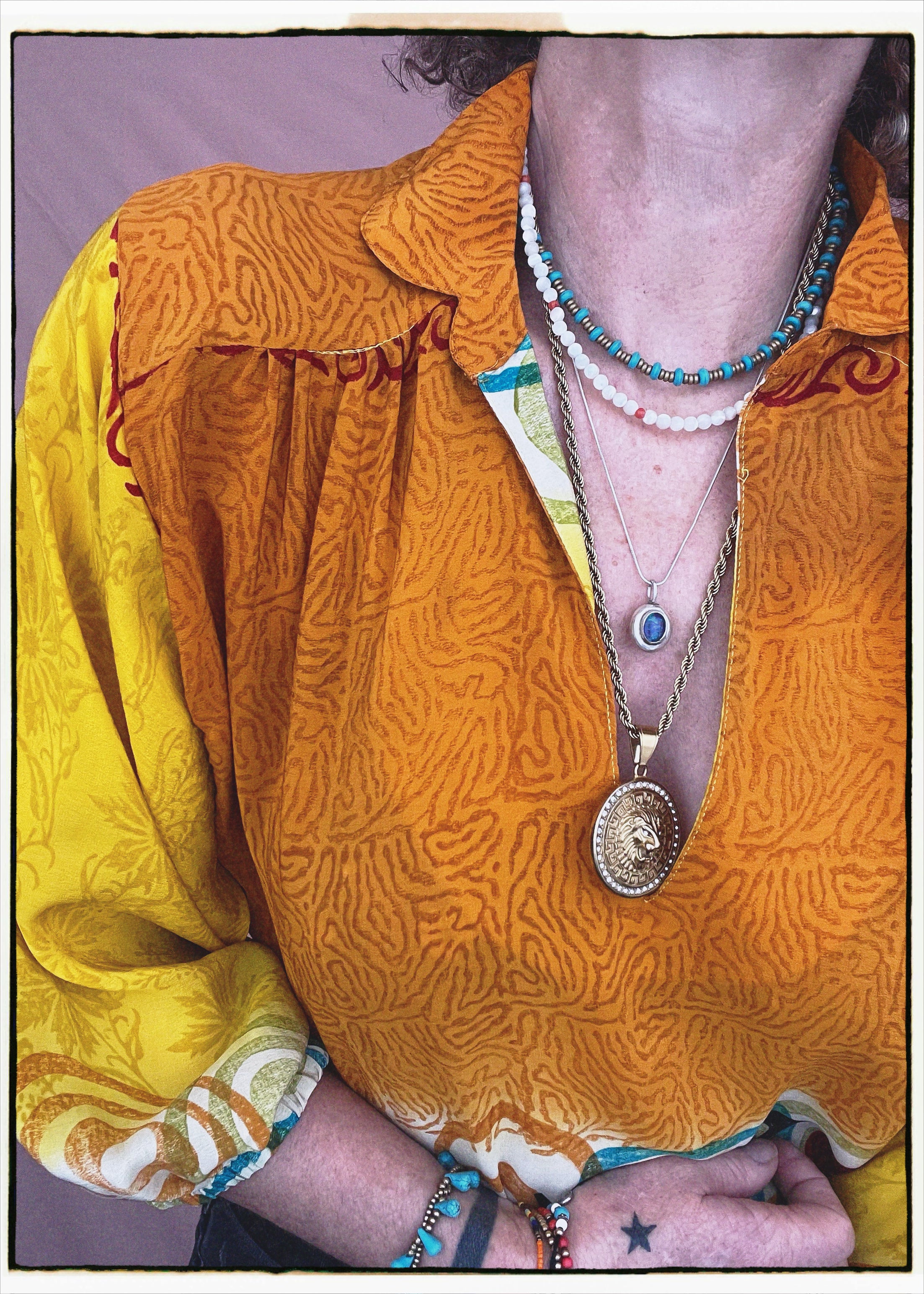 Woman wearing a bohemian style balloon sleeved blouse made from vintage repurposed Indian silk crepe sari in front of a plain background