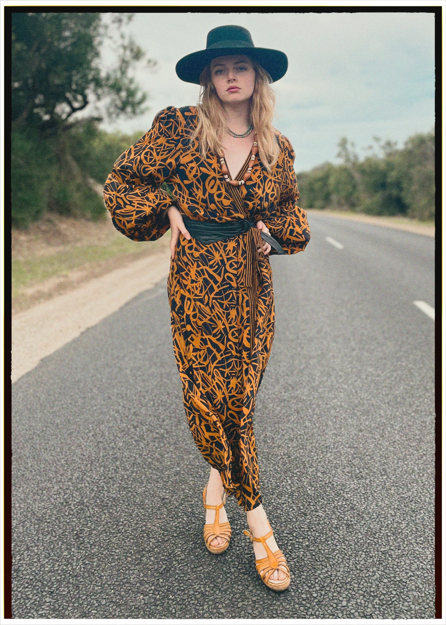 Woman wearing a bohemian style balloon sleeved wrap dress made from vintage repurposed Indian silk crepe sari in front of a plain 