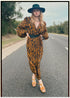 Woman wearing a bohemian style balloon sleeved wrap dress made from vintage repurposed Indian silk crepe sari in front of a plain 