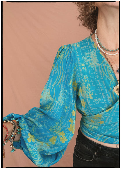 Woman wearing a bohemian style balloon sleeved patterned blouse made from vintage repurposed Indian silk crepe sari in front of a plain background