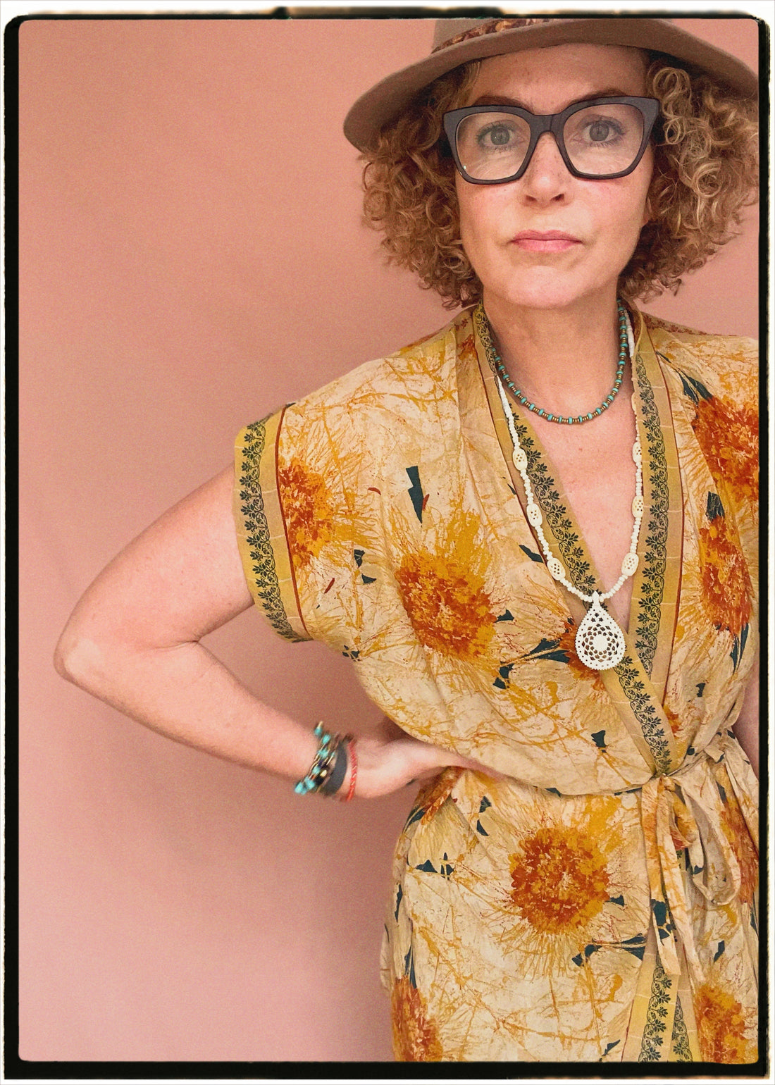 Woman wearing a bohemian style balloon sleeved patterned blouse made from vintage repurposed Indian silk crepe sari in front of a plain background