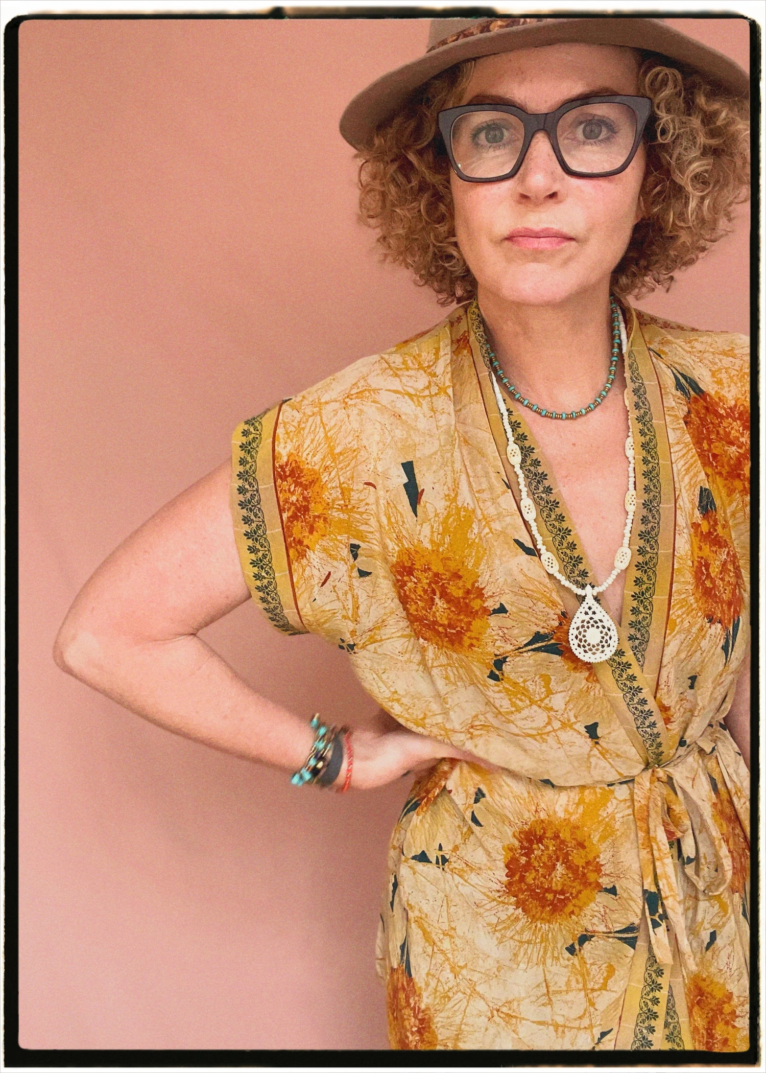Woman wearing a bohemian style balloon sleeved patterned blouse made from vintage repurposed Indian silk crepe sari in front of a plain background
