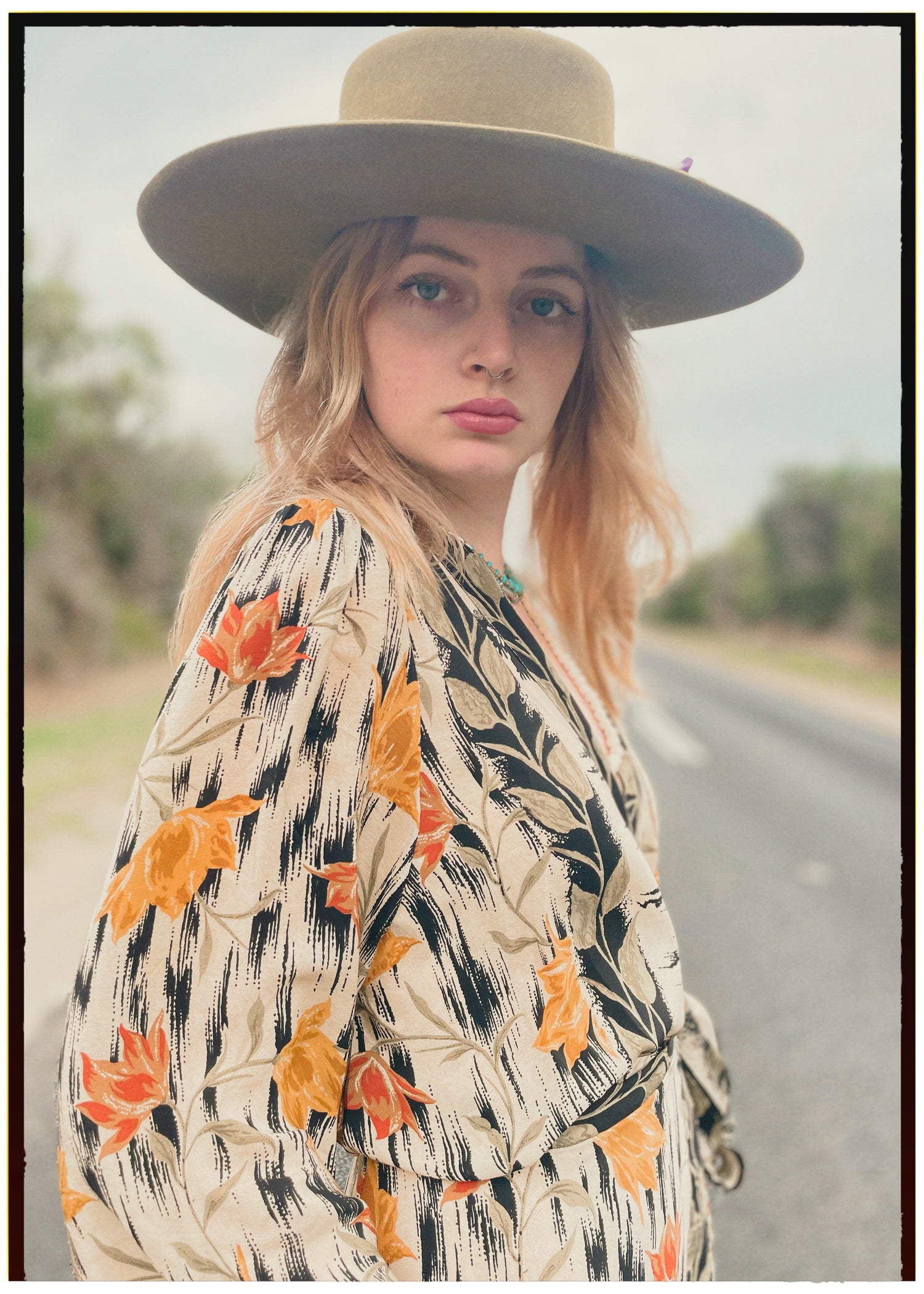Woman wearing a bohemian style balloon sleeved wrap dress made from vintage repurposed Indian silk crepe sari in front of a plain 