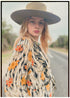 Woman wearing a bohemian style balloon sleeved wrap dress made from vintage repurposed Indian silk crepe sari in front of a plain 