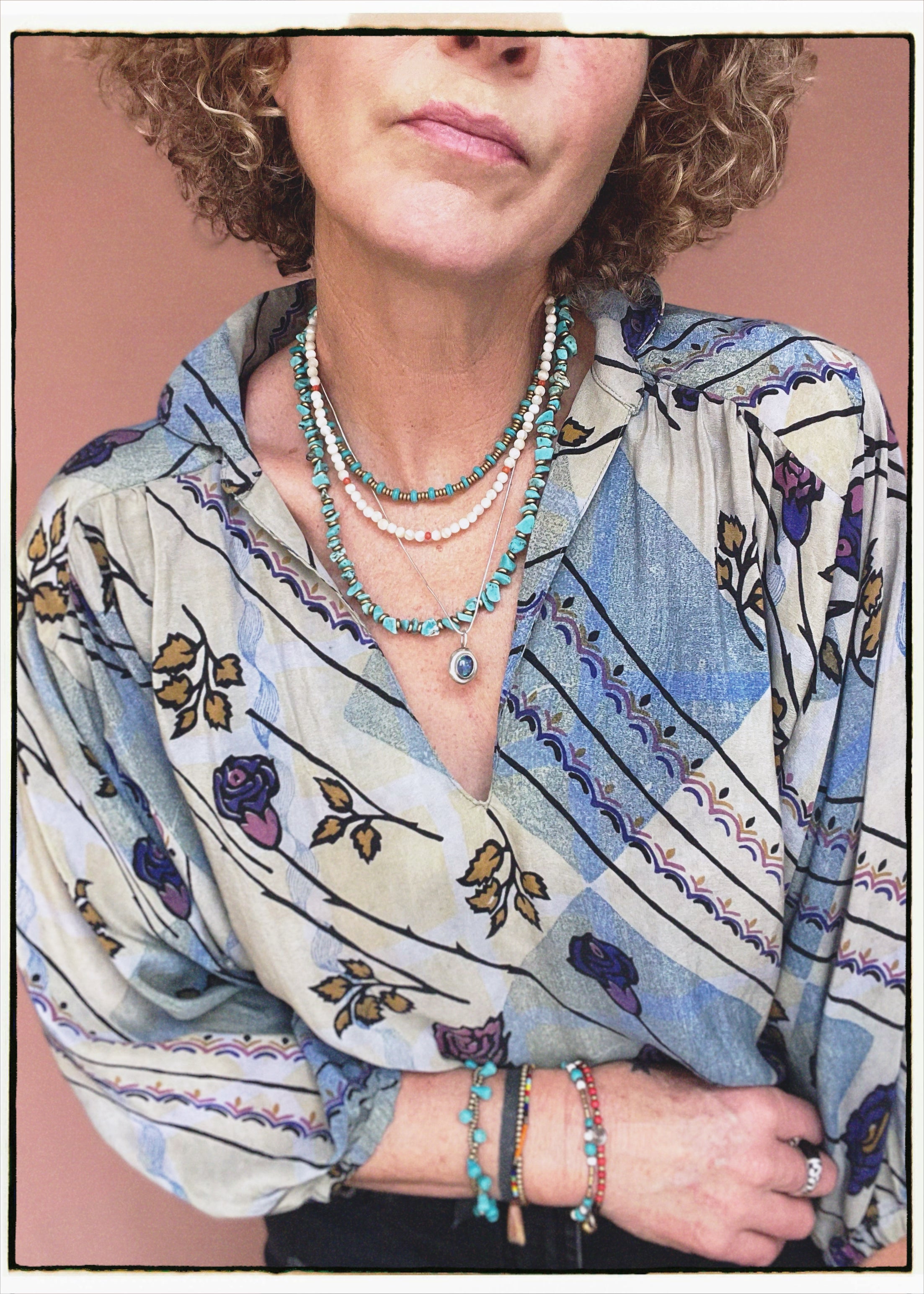 Woman wearing a bohemian style balloon sleeved patterned blouse made from vintage repurposed Indian silk crepe sari in front of a plain background
