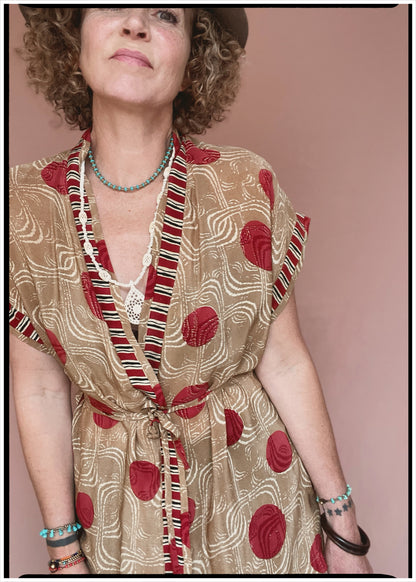 Woman wearing a bohemian style balloon sleeved patterned blouse made from vintage repurposed Indian silk crepe sari in front of a plain background