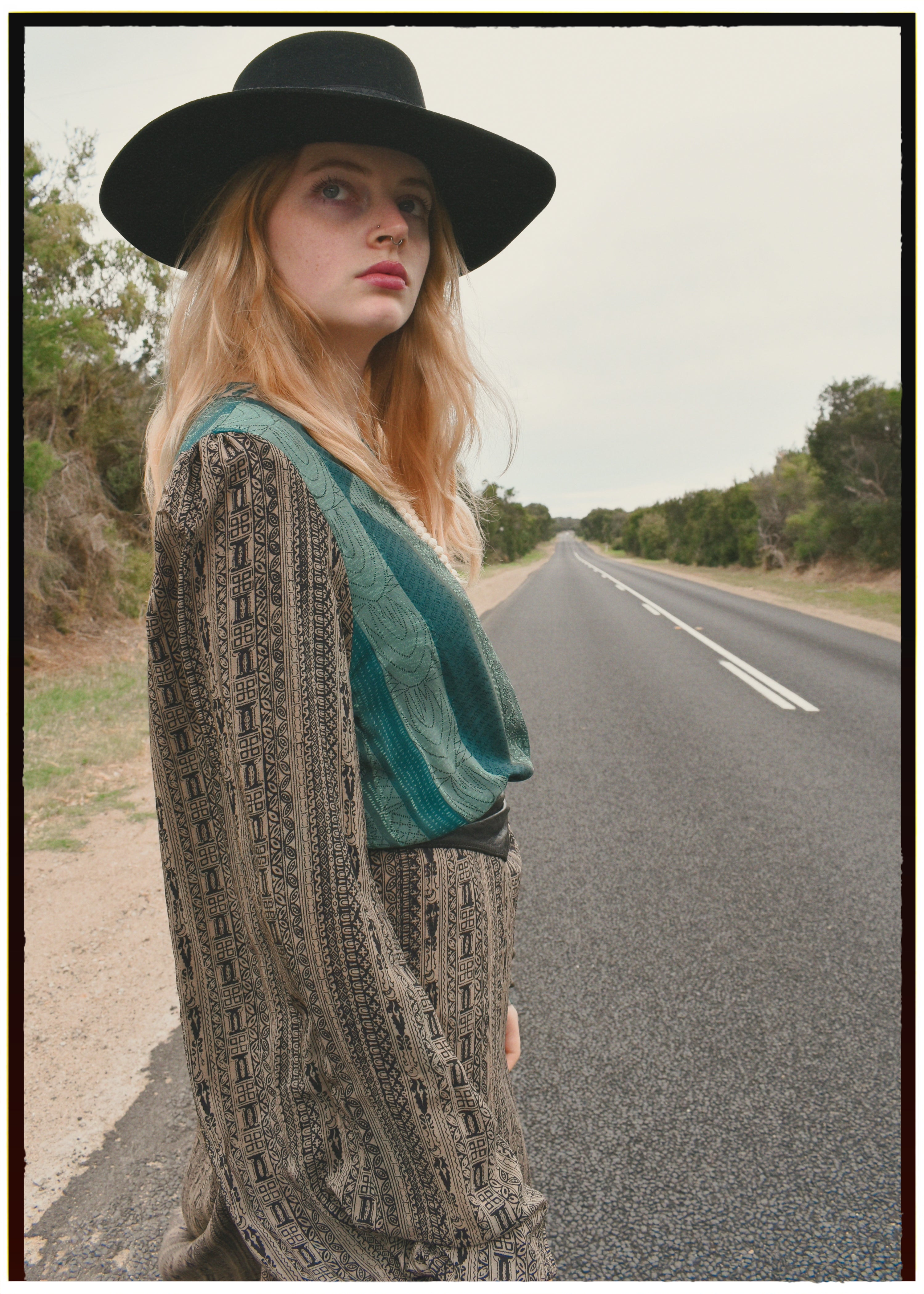 Woman wearing a bohemian style balloon sleeved wrap dress made from vintage repurposed Indian silk crepe sari in front of a plain 