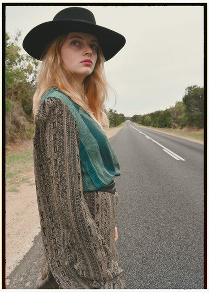Woman wearing a bohemian style balloon sleeved wrap dress made from vintage repurposed Indian silk crepe sari in front of a plain 