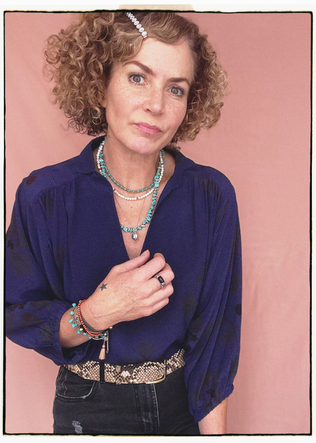 Woman wearing a bohemian style balloon sleeved blouse made from vintage repurposed Indian silk crepe sari in front of a plain background