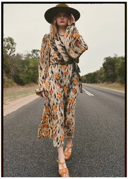 Woman wearing a bohemian style balloon sleeved wrap dress made from vintage repurposed Indian silk crepe sari in front of a plain 