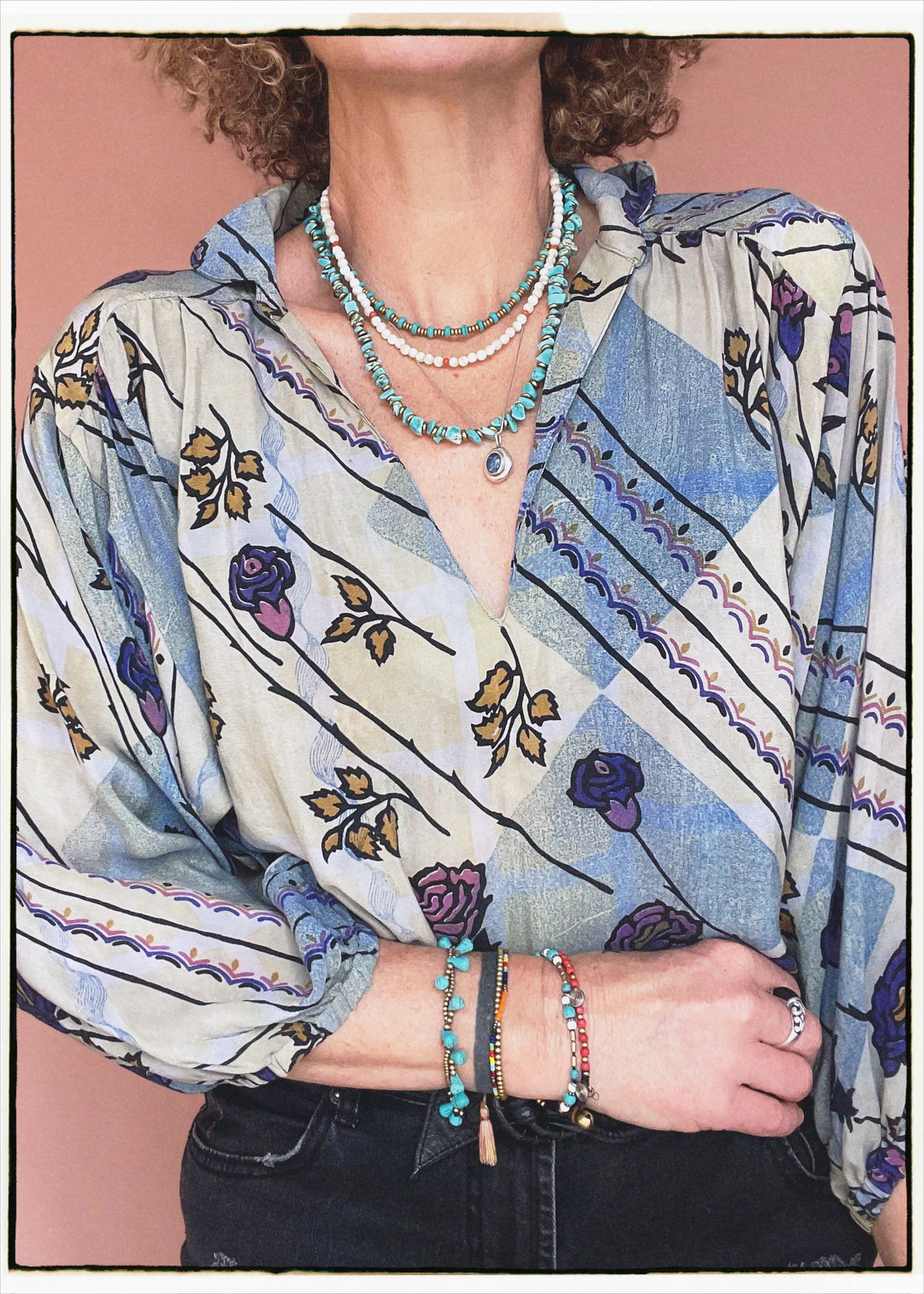Woman wearing a bohemian style balloon sleeved patterned blouse made from vintage repurposed Indian silk crepe sari in front of a plain background