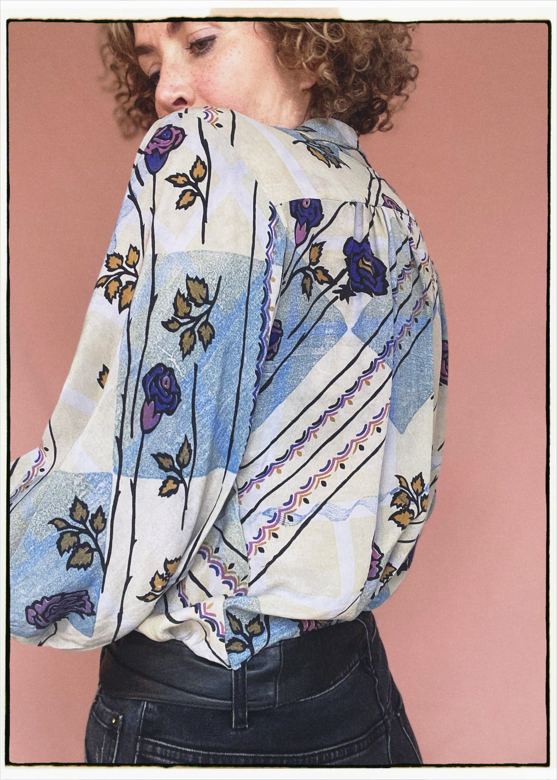 Woman wearing a bohemian style balloon sleeved patterned blouse made from vintage repurposed Indian silk crepe sari in front of a plain background