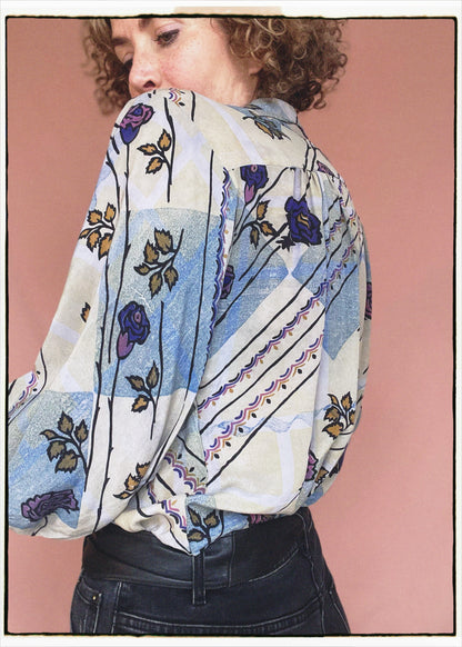 Woman wearing a bohemian style balloon sleeved patterned blouse made from vintage repurposed Indian silk crepe sari in front of a plain background