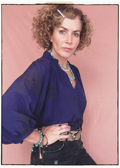 Woman wearing a bohemian style balloon sleeved blouse made from vintage repurposed Indian silk crepe sari in front of a plain background
