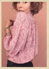 Woman wearing a bohemian style balloon sleeved patterned blouse made from vintage repurposed Indian silk crepe sari in front of a plain background