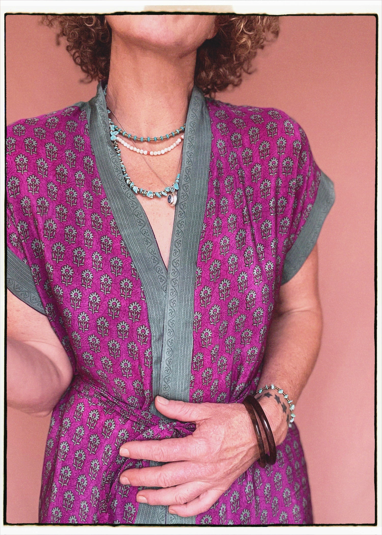 Woman wearing a bohemian style balloon sleeved patterned blouse made from vintage repurposed Indian silk crepe sari in front of a plain background
