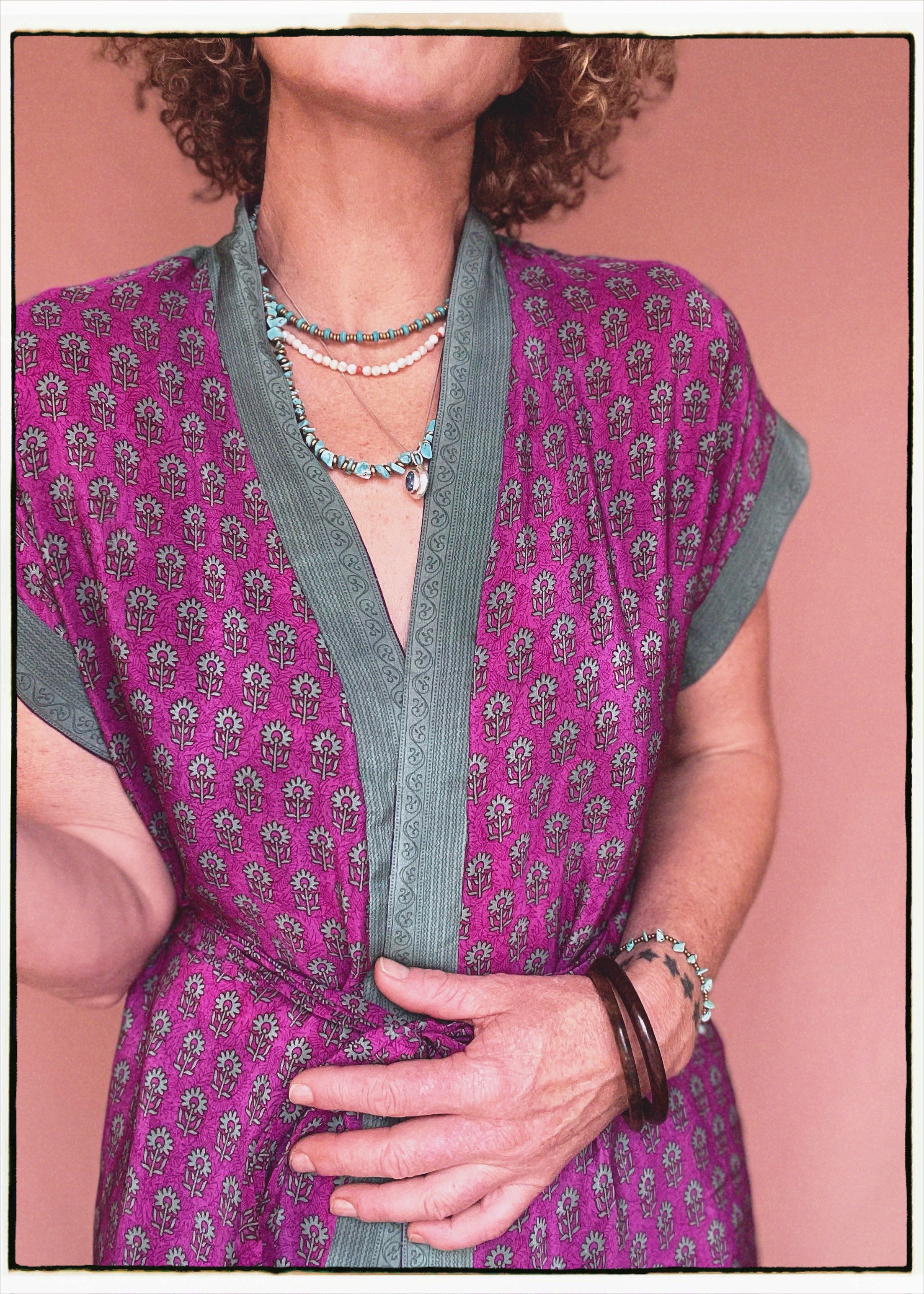 Woman wearing a bohemian style balloon sleeved patterned blouse made from vintage repurposed Indian silk crepe sari in front of a plain background