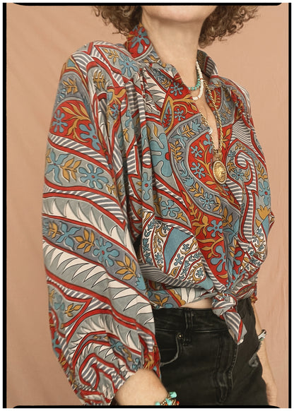 Woman wearing a bohemian style balloon sleeved patterned blouse made from vintage repurposed Indian silk crepe sari in front of a plain background