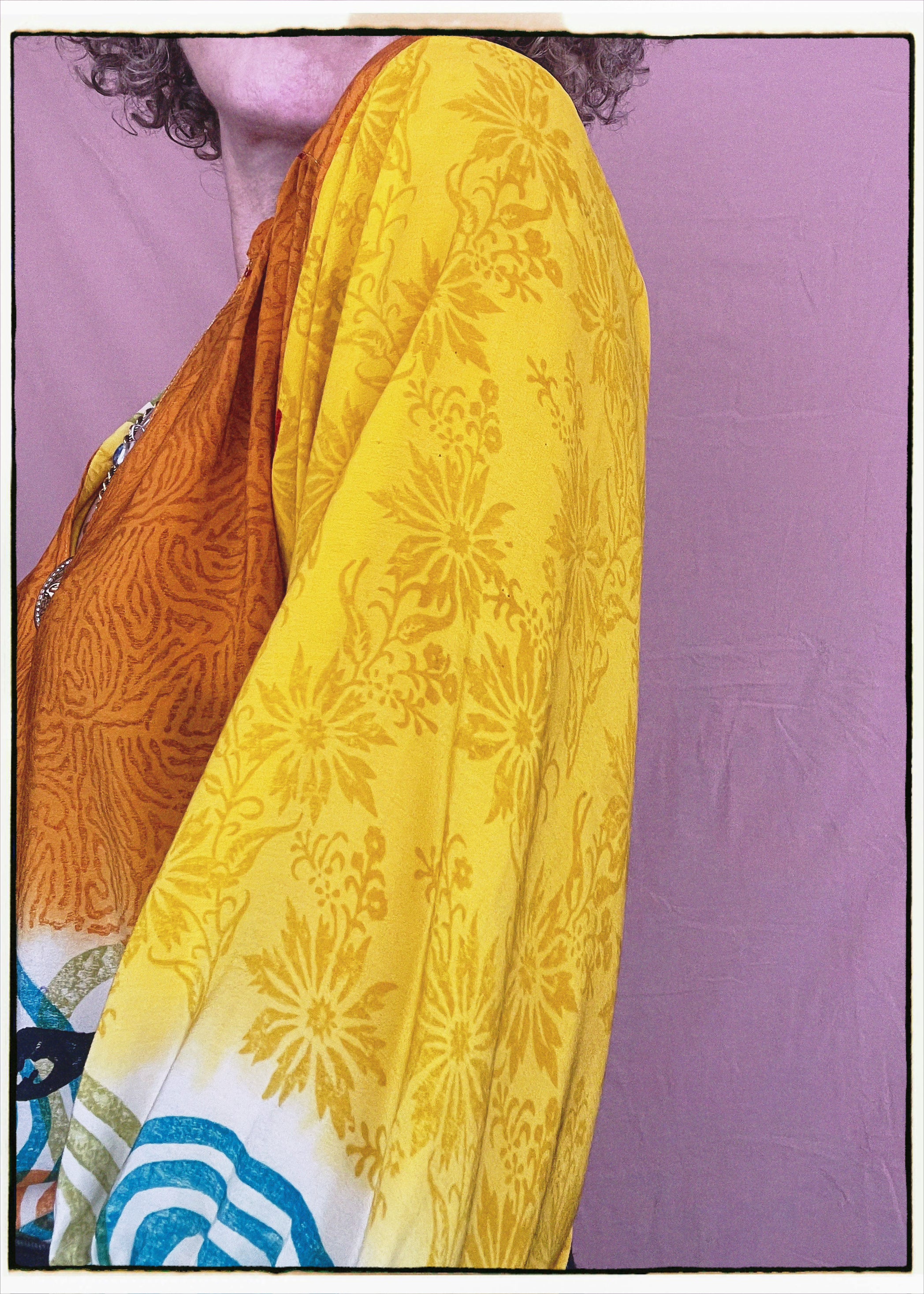Woman wearing a bohemian style balloon sleeved blouse made from vintage repurposed Indian silk crepe sari in front of a plain background