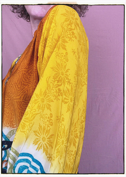 Woman wearing a bohemian style balloon sleeved blouse made from vintage repurposed Indian silk crepe sari in front of a plain background