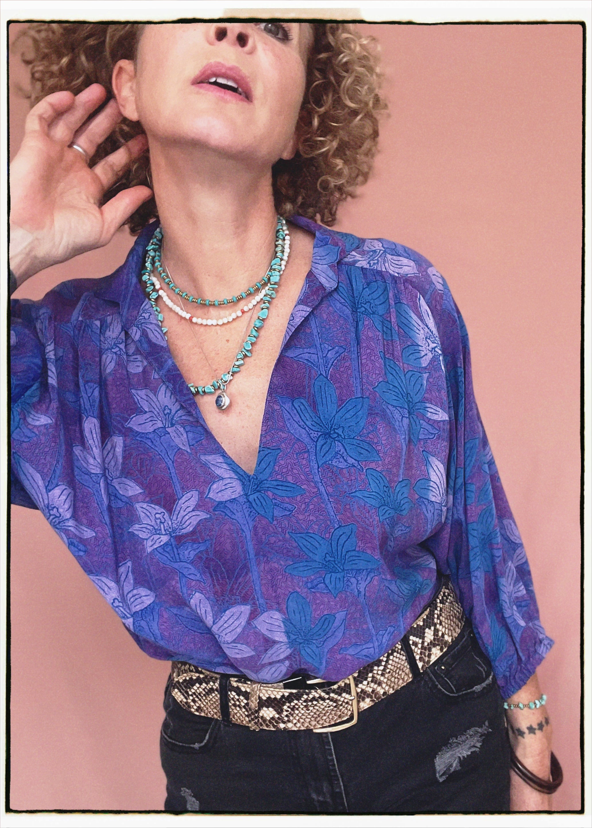Woman wearing a bohemian style balloon sleeved patterned blouse made from vintage repurposed Indian silk crepe sari in front of a plain background