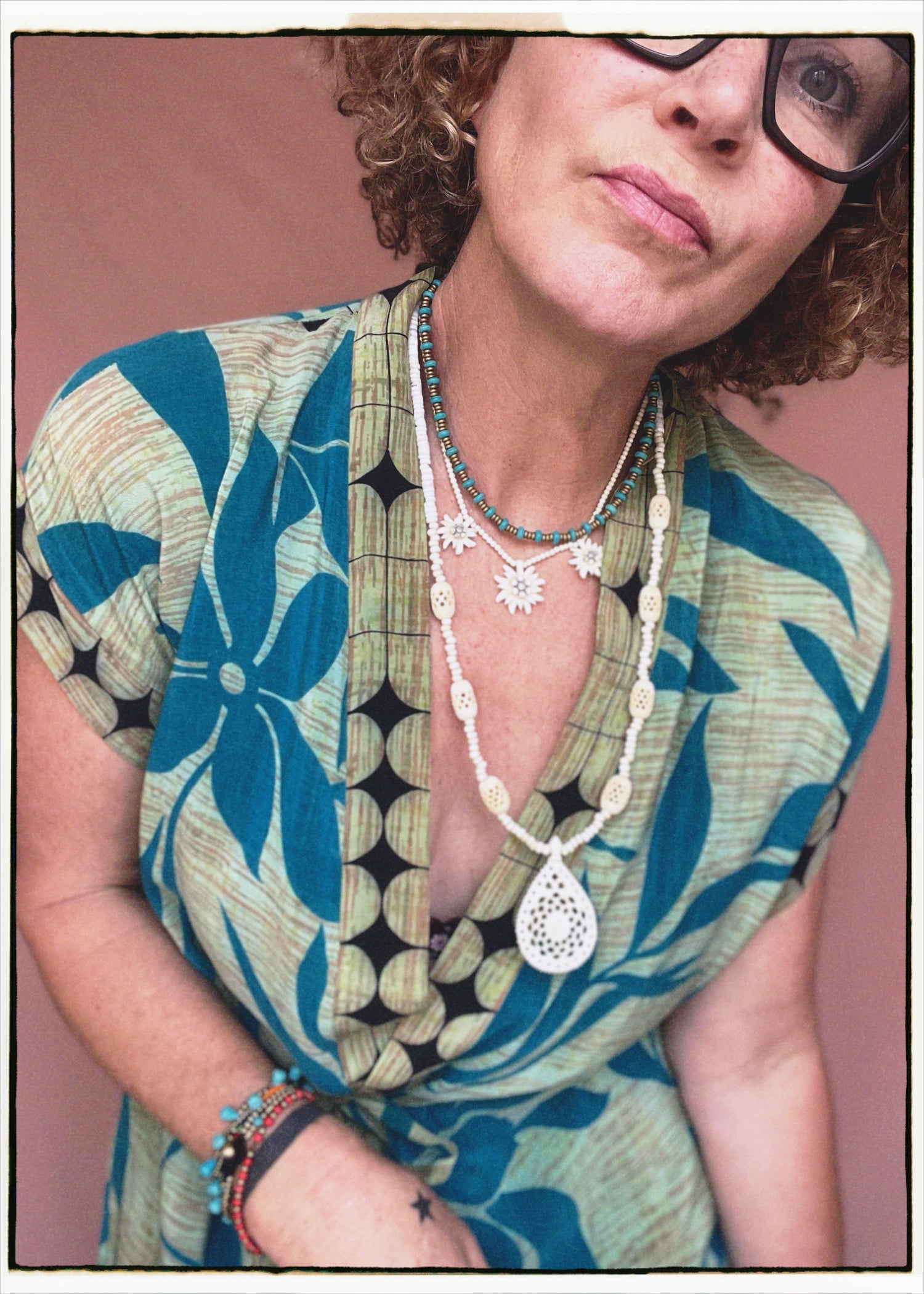 Woman wearing a bohemian style balloon sleeved patterned blouse made from vintage repurposed Indian silk crepe sari in front of a plain background