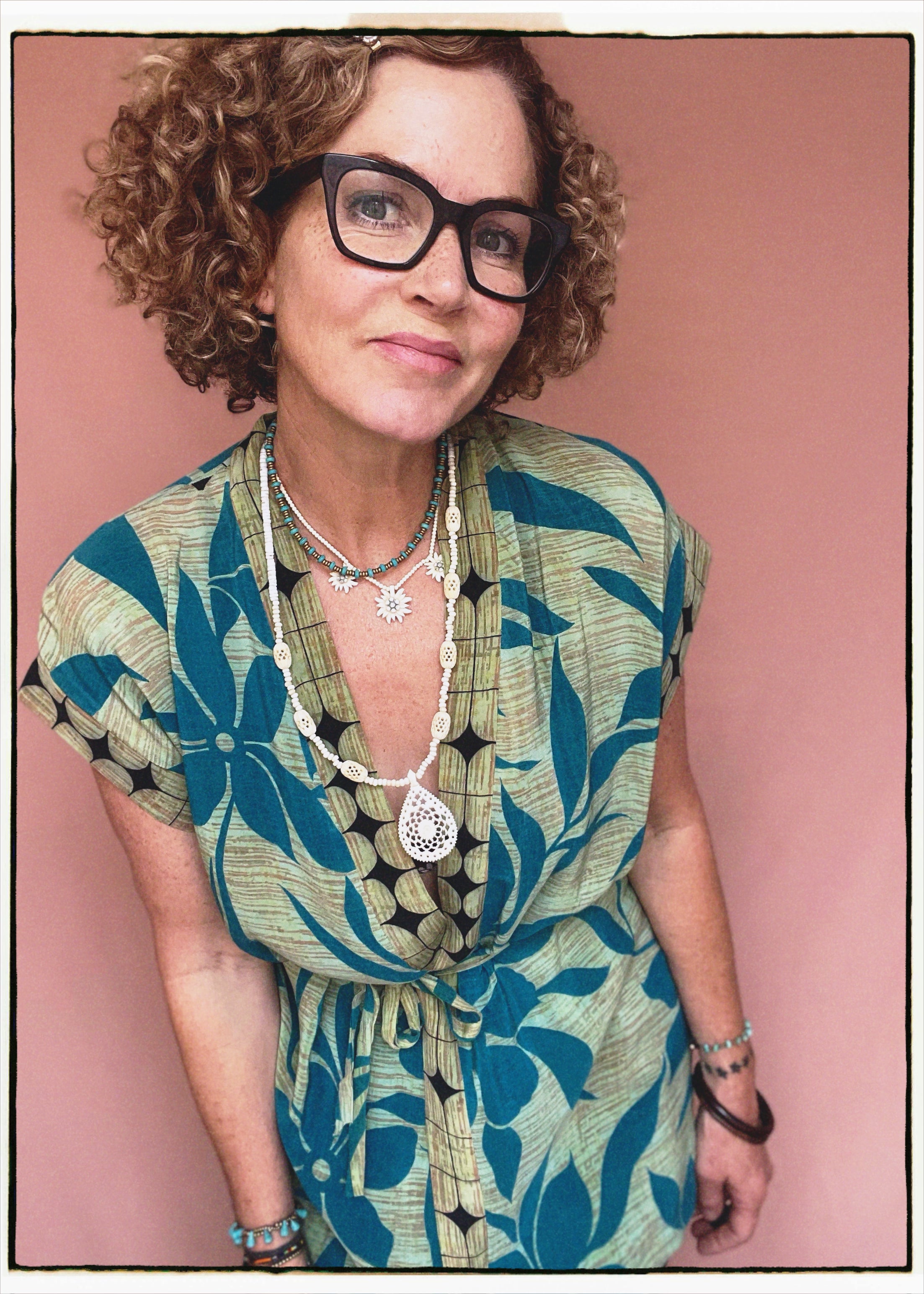 Woman wearing a bohemian style balloon sleeved patterned blouse made from vintage repurposed Indian silk crepe sari in front of a plain background