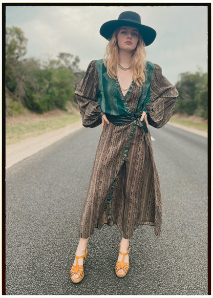 Woman wearing a bohemian style balloon sleeved wrap dress made from vintage repurposed Indian silk crepe sari in front of a plain 