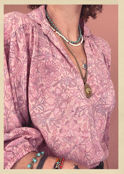 Woman wearing a bohemian style balloon sleeved patterned blouse made from vintage repurposed Indian silk crepe sari in front of a plain background