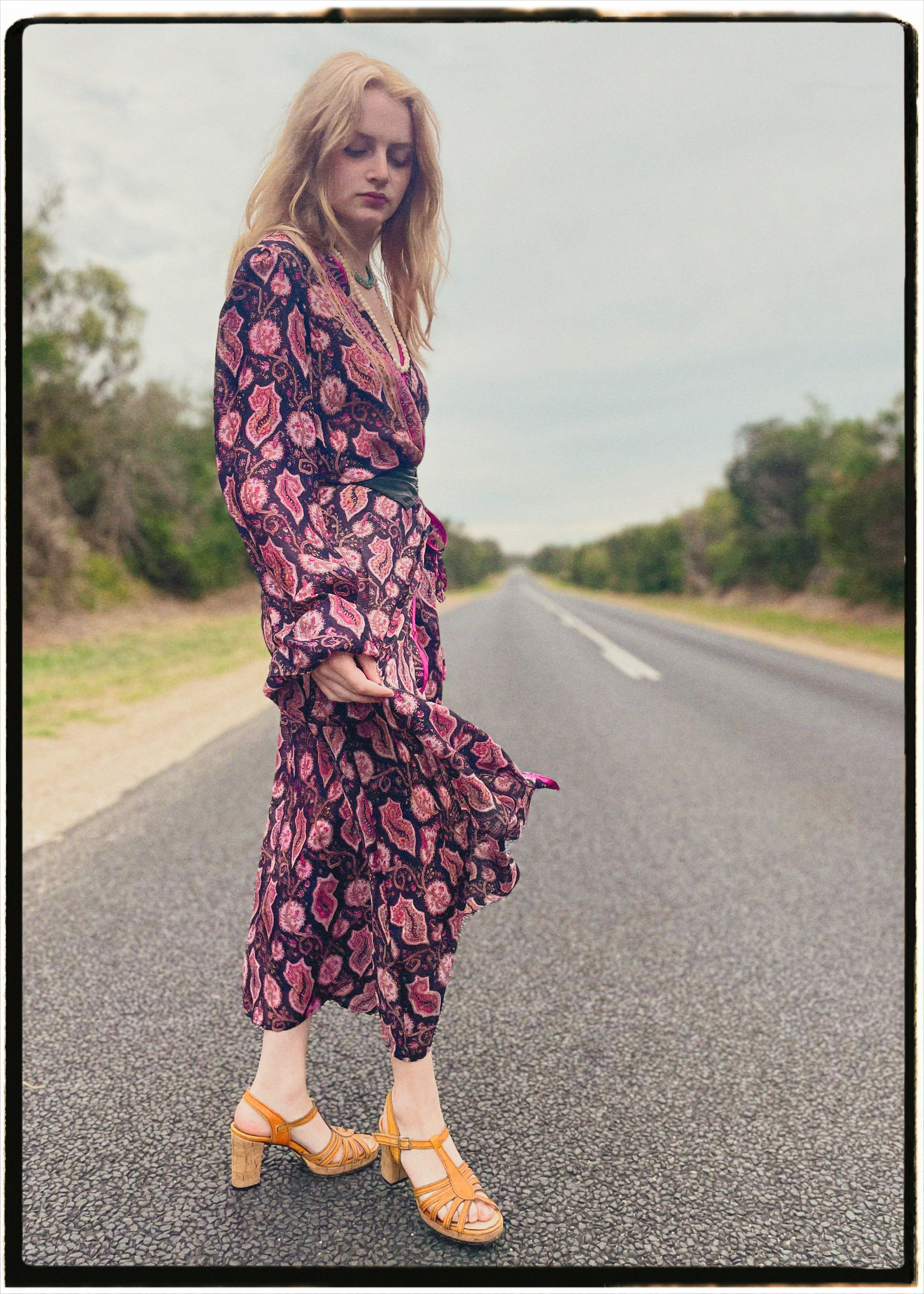 Woman wearing a bohemian style balloon sleeved wrap dress made from vintage repurposed Indian silk crepe sari in front of a plain 