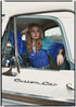 Woman wearing a bohemian style balloon sleeved blouse made from vintage Indian repurposed silk crepe saree sitting in the back of a vintage car with a scenic background