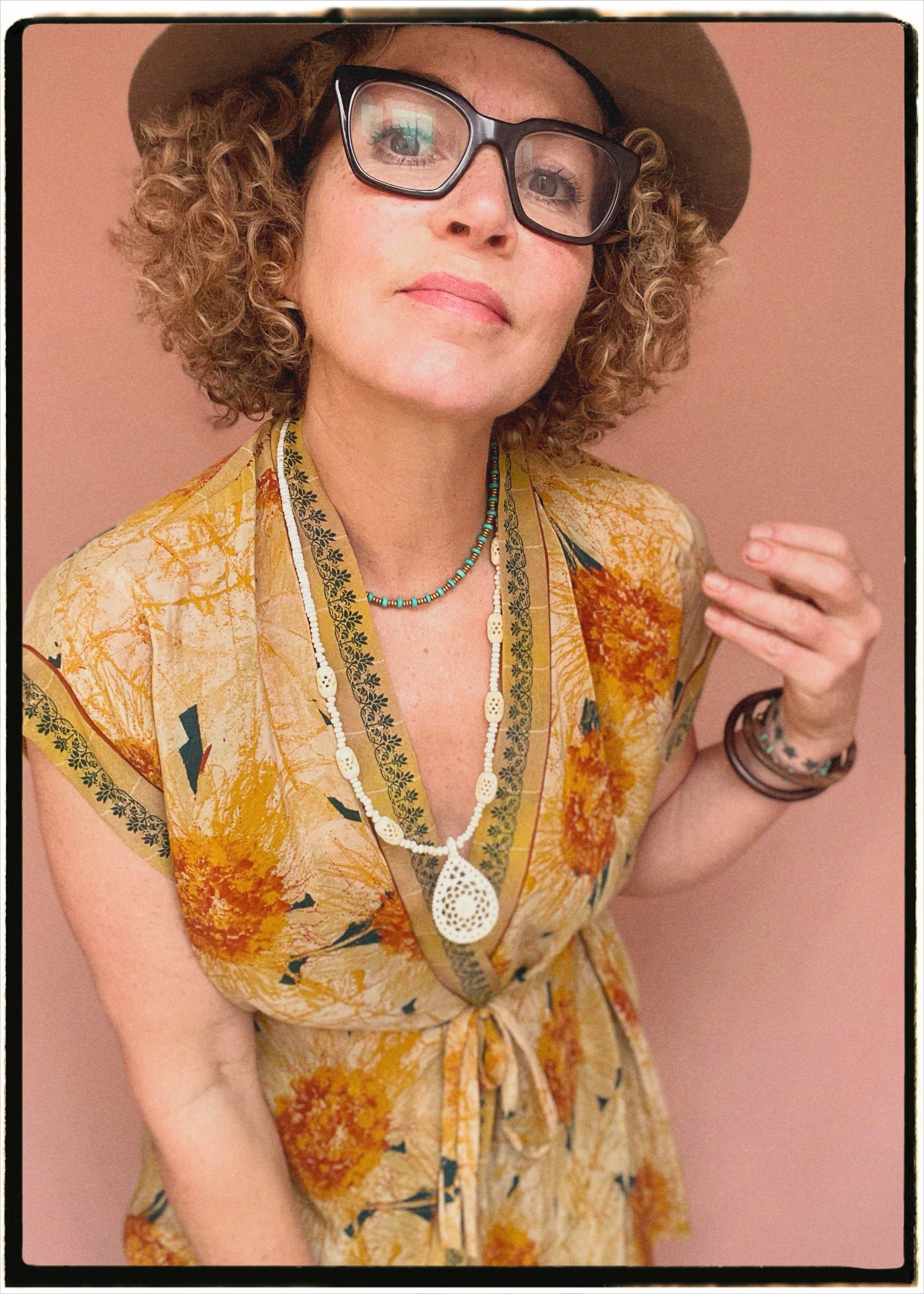Woman wearing a bohemian style balloon sleeved patterned blouse made from vintage repurposed Indian silk crepe sari in front of a plain background