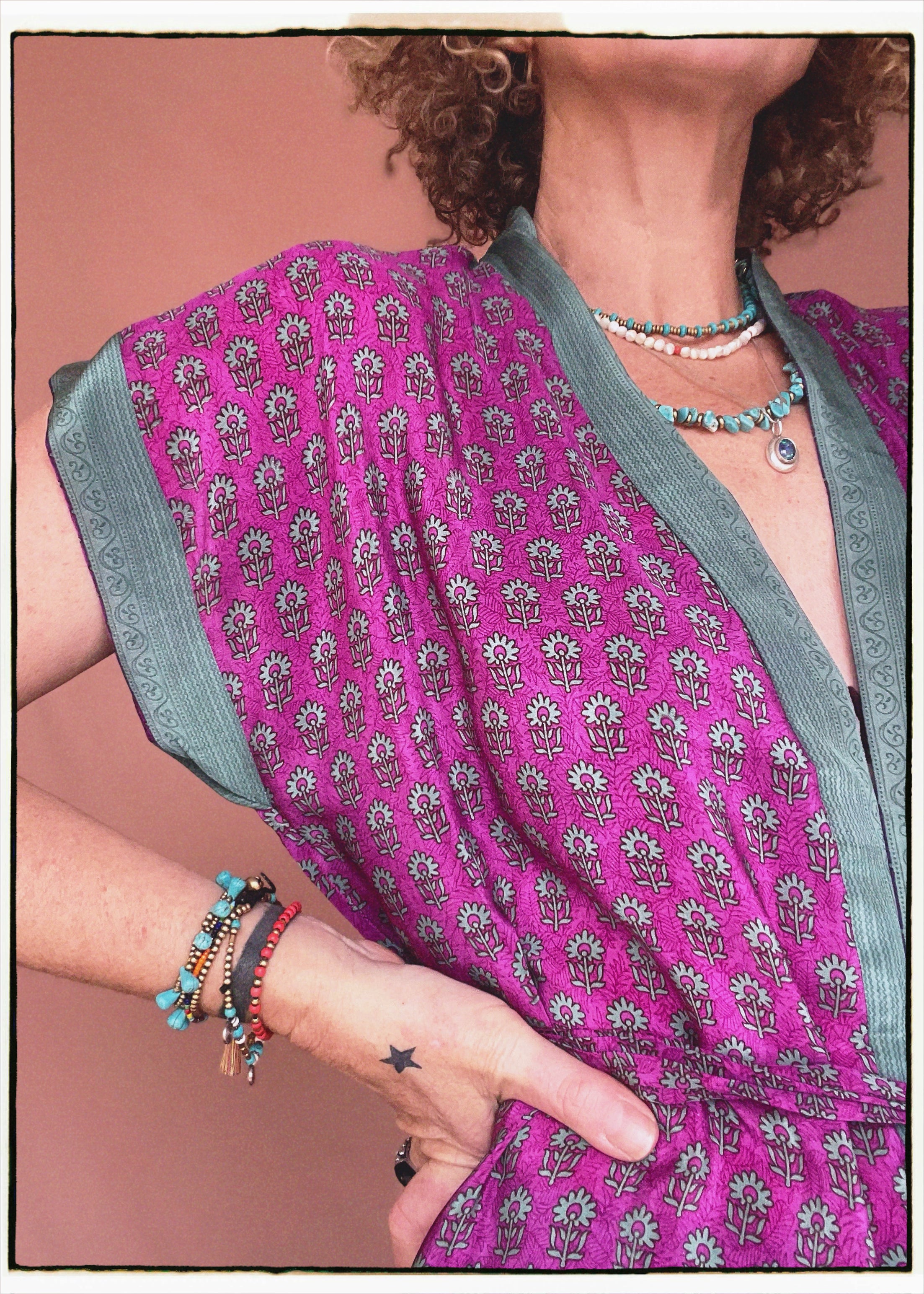 Woman wearing a bohemian style balloon sleeved patterned blouse made from vintage repurposed Indian silk crepe sari in front of a plain background